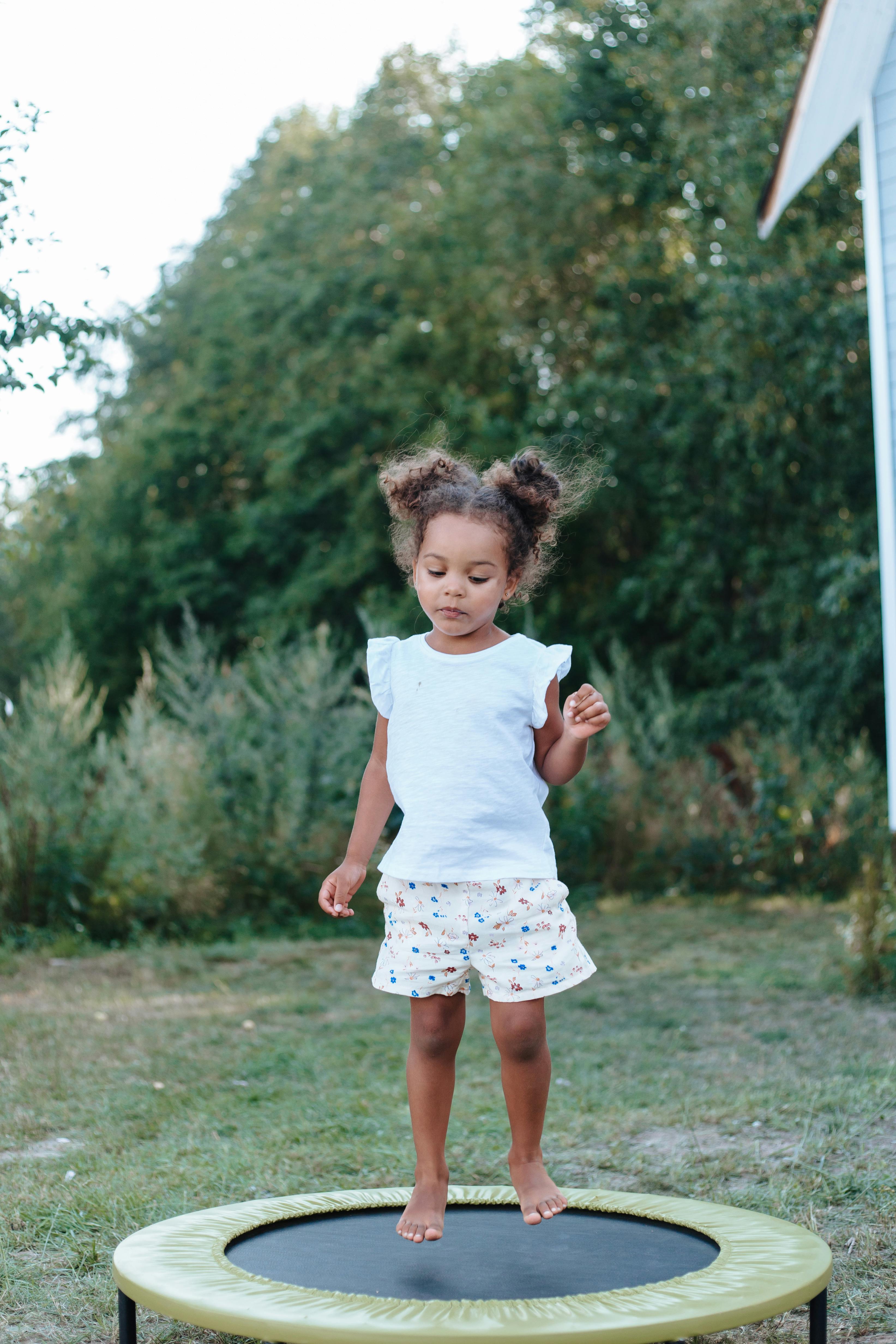 A little girl on a trampoline | Source: Pexels