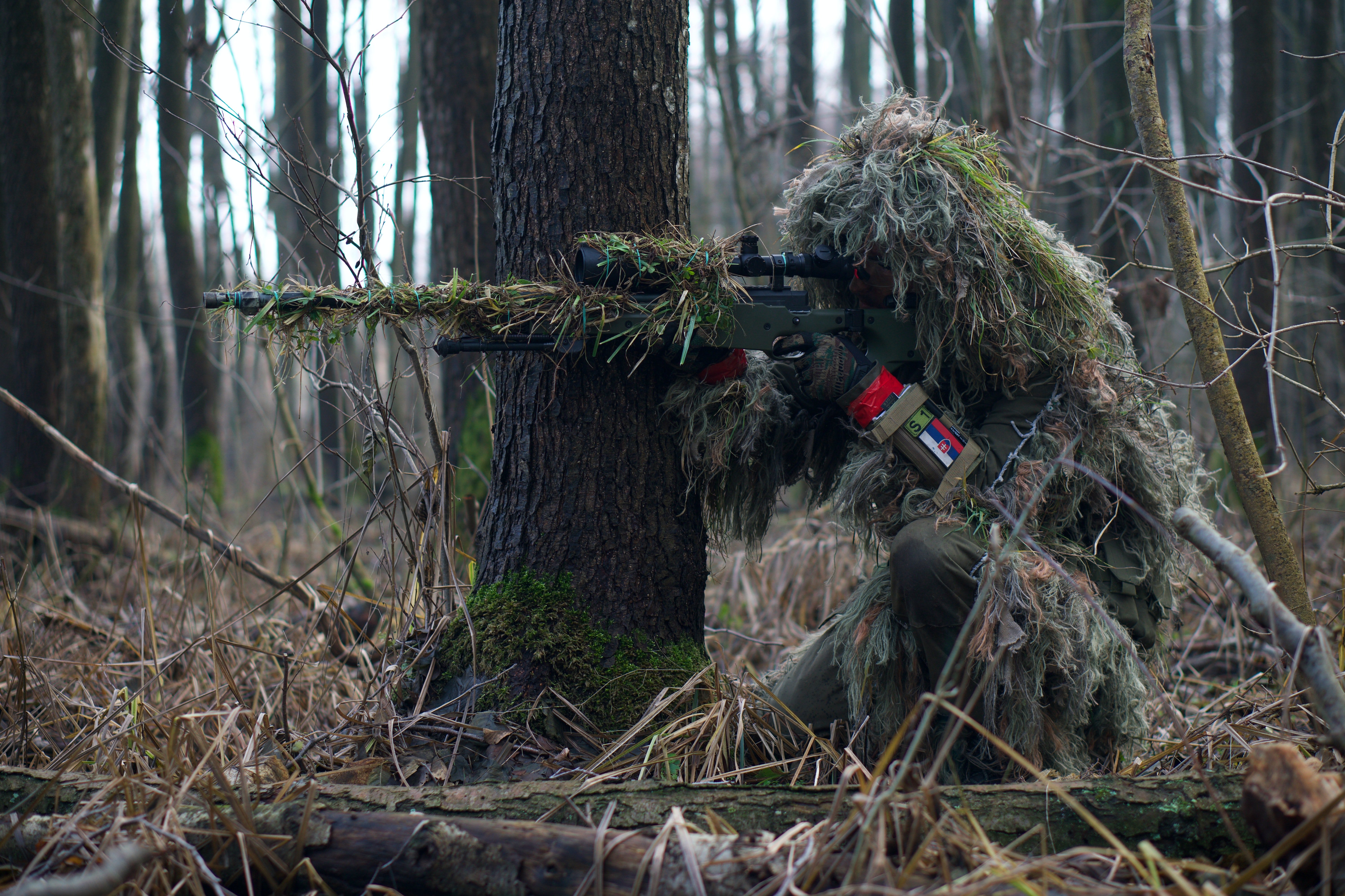 A man on camouflage shooting in the woods. | Pexels/  Kony Xyzx 
