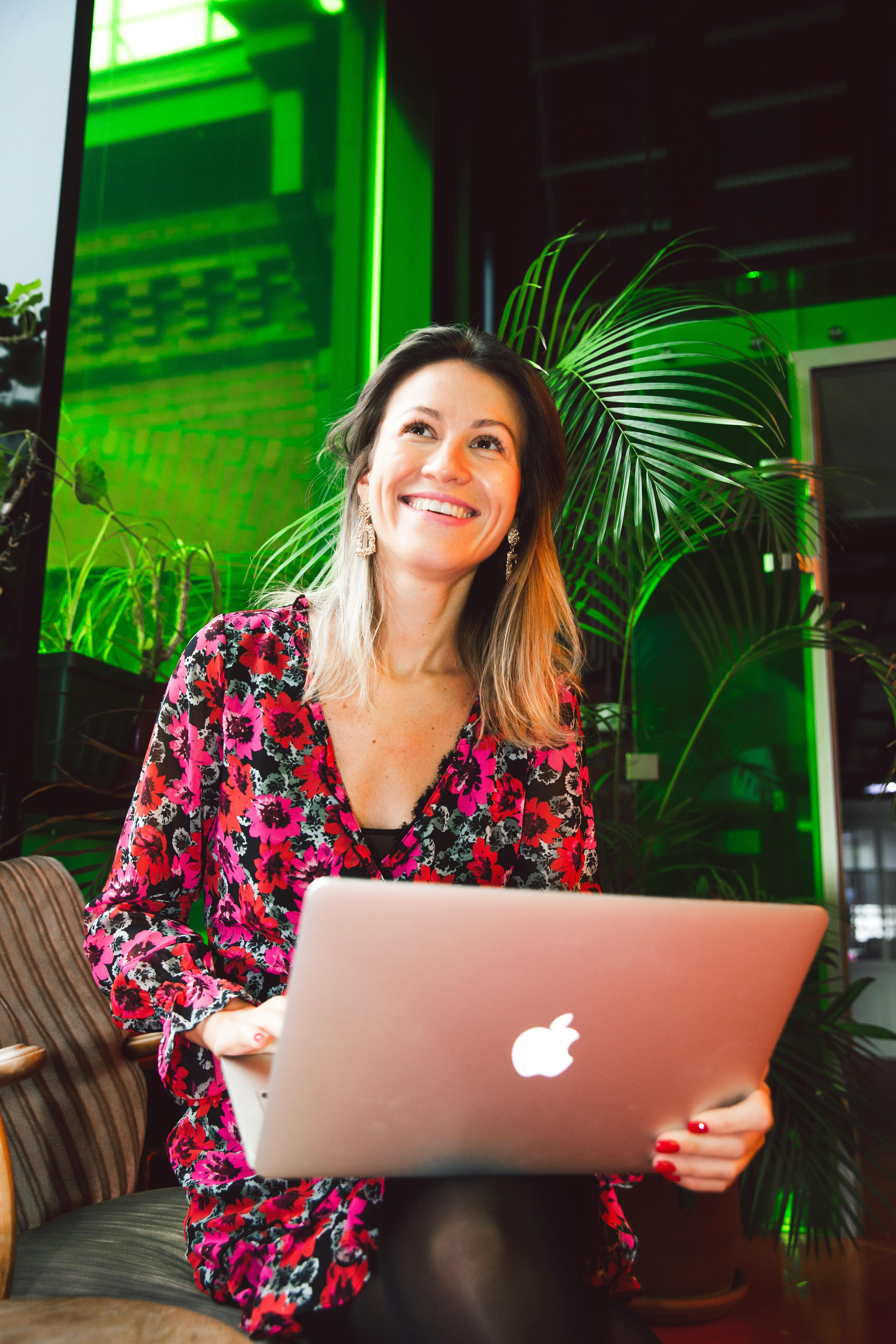 A happy woman holding a laptop | Source: Pexels