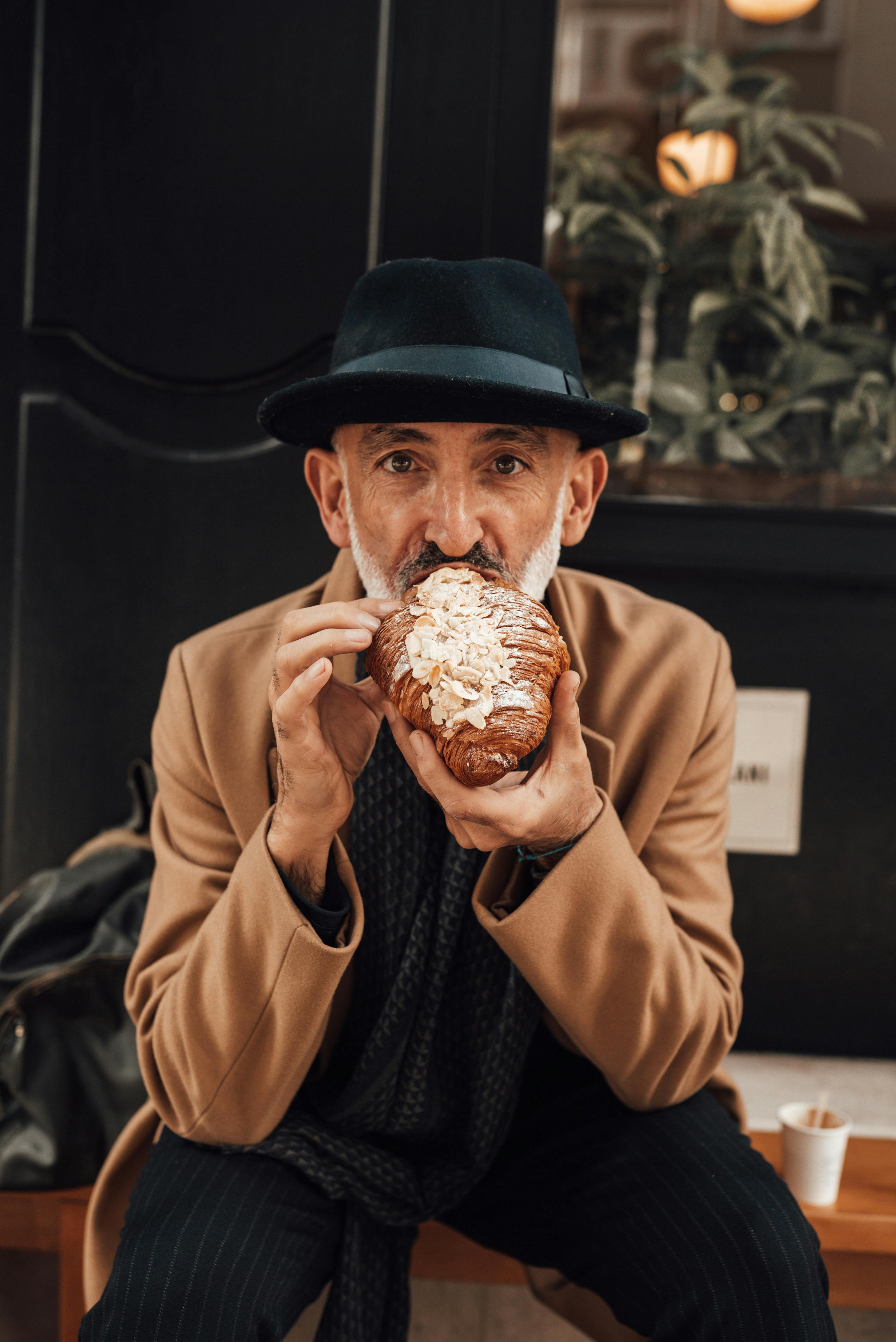 An elderly man eating a croissant | Source: Pexels