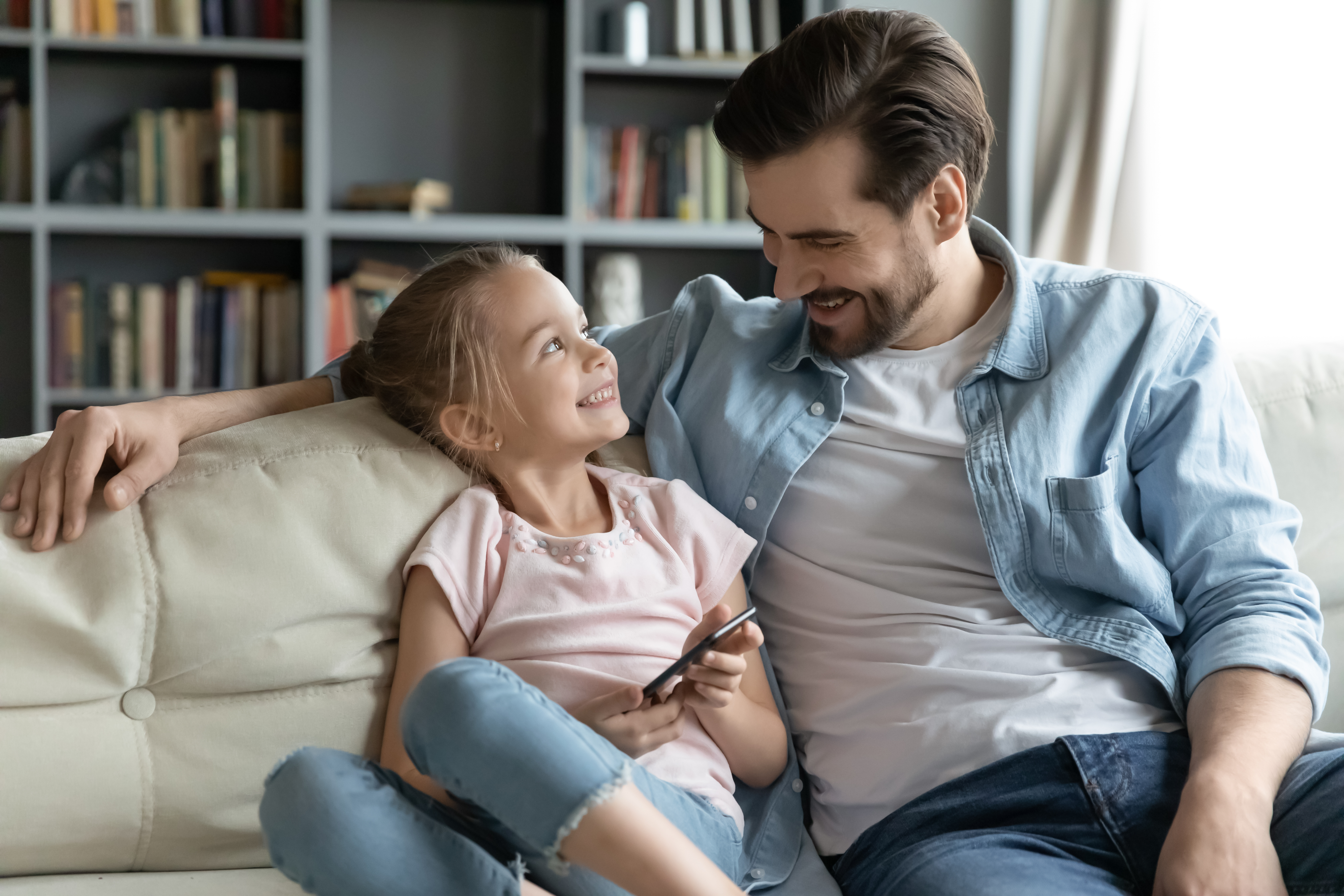 A little girl spending time with her dad at home | Source: Shutterstock