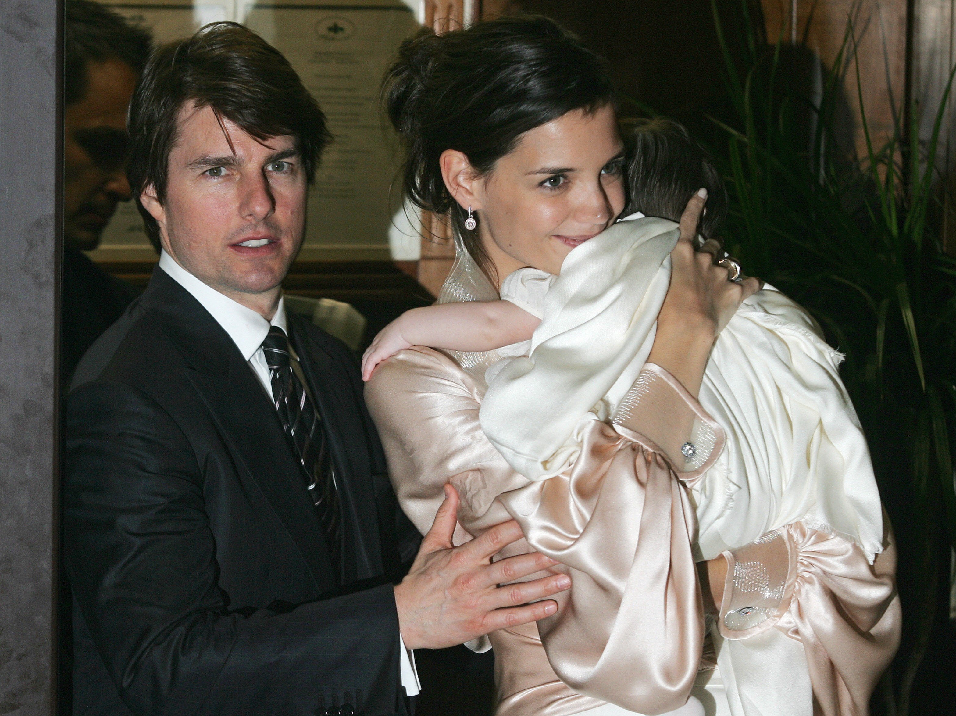 Tom Cruise and his fiancee Katie Holmes, holding their daughter Suri, leave a restaurant in central Rome, early 17 November 2006 | Source: Getty Images