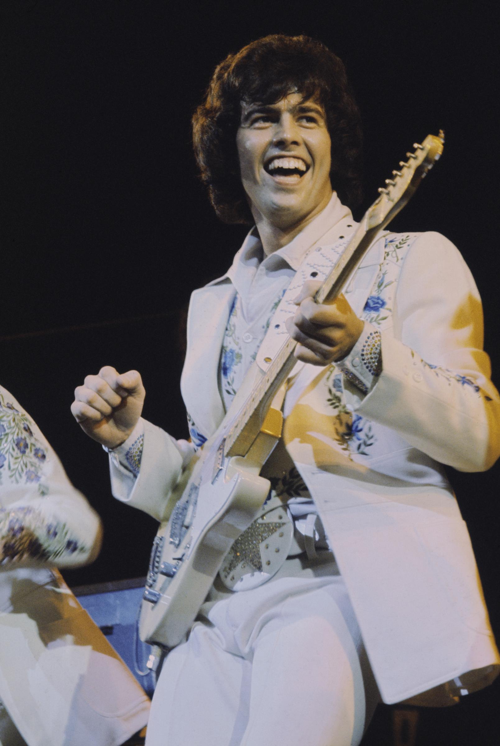 Alan Osmond performs live on stage with "The Osmonds" on the British leg of their European tour in October 1973 | Source: Getty Images