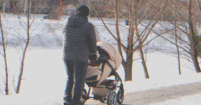 A man pushing a baby stroller on a snowy day | Source: Shutterstock