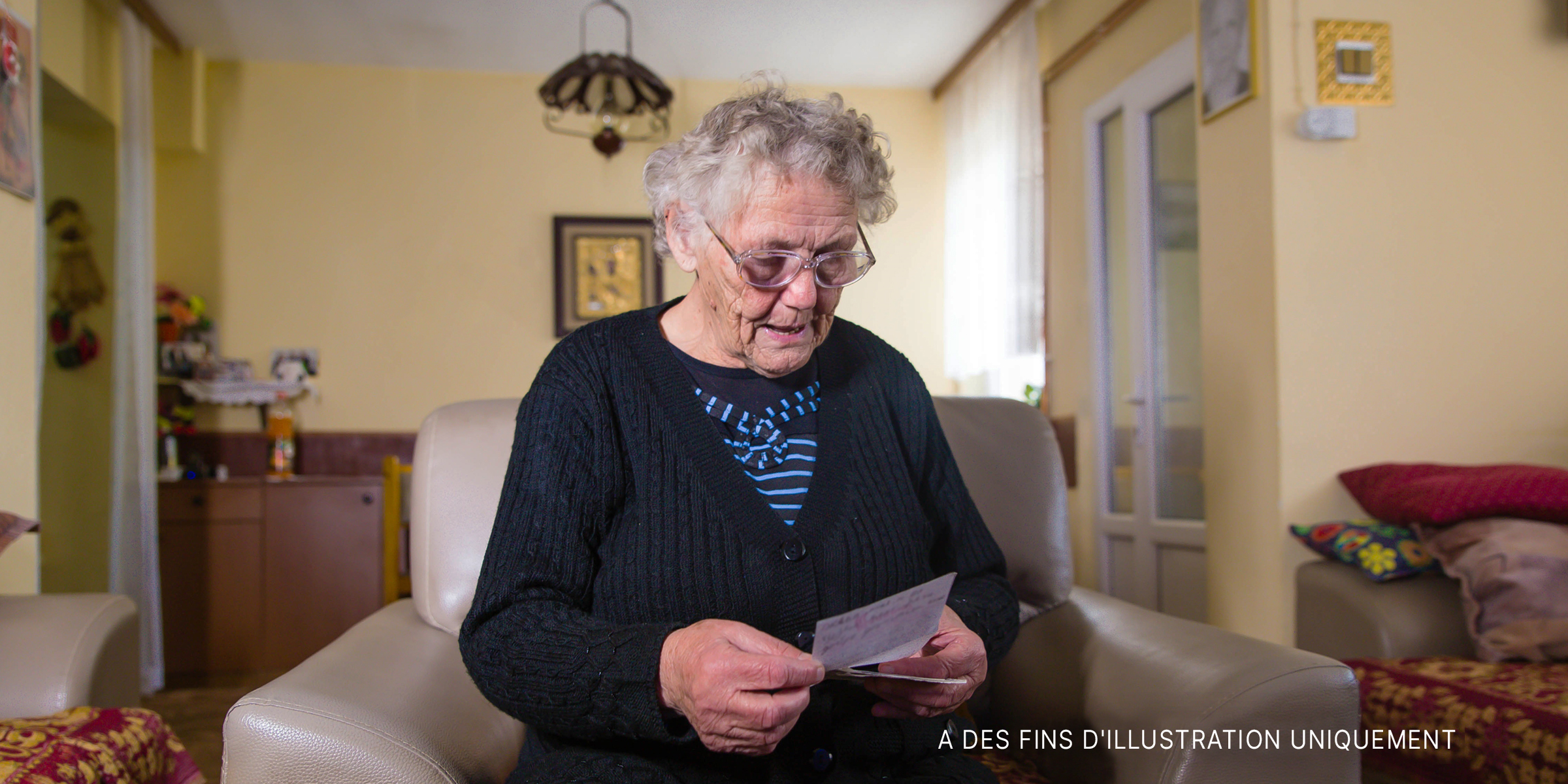 Une femme seule et âgée lisant une lettre dans sa chambre | Source : Getty Images