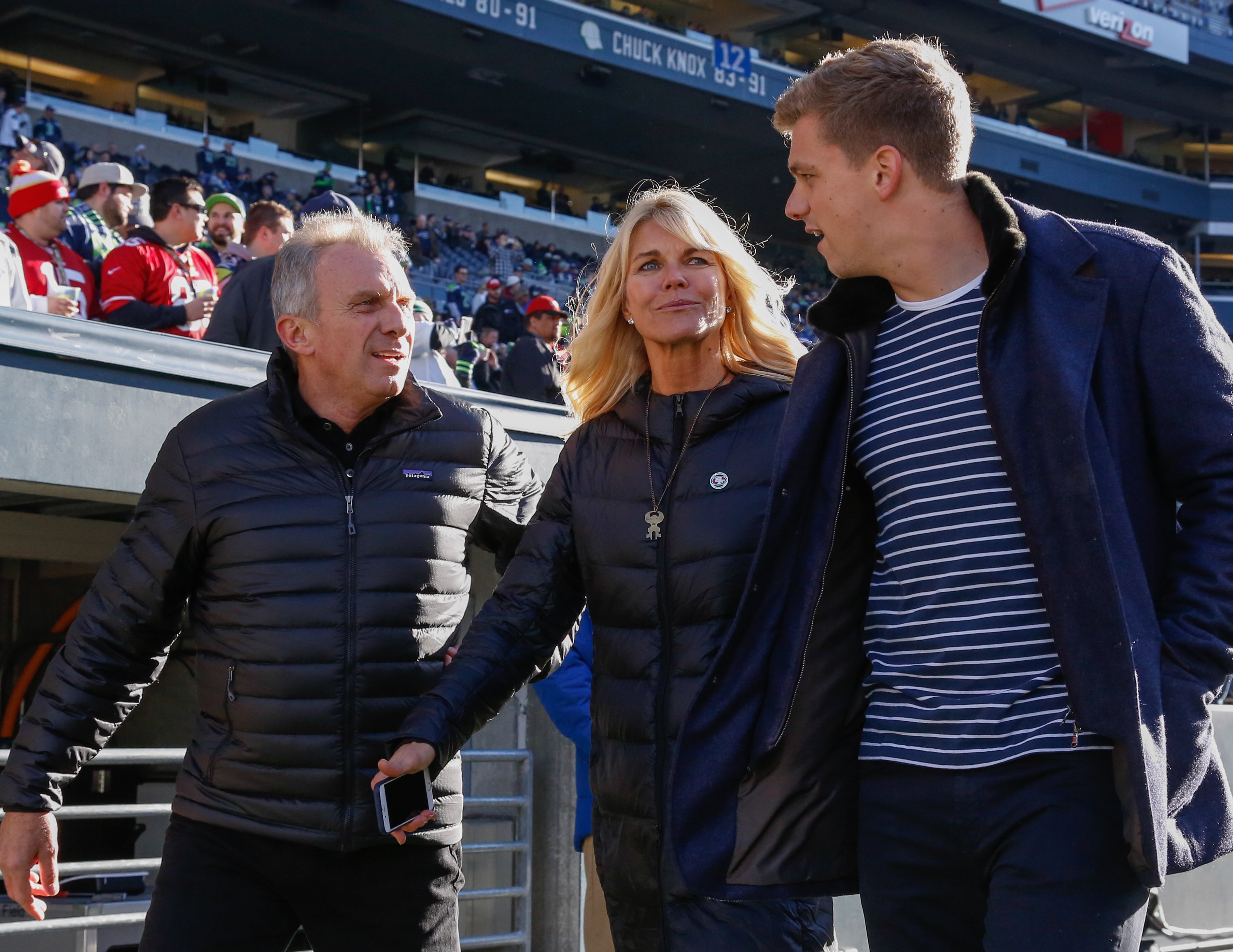 Joe Montana, his wife Jennifer, and their son Nick walking the sidelines before a game in Seattle | Source: Getty Images