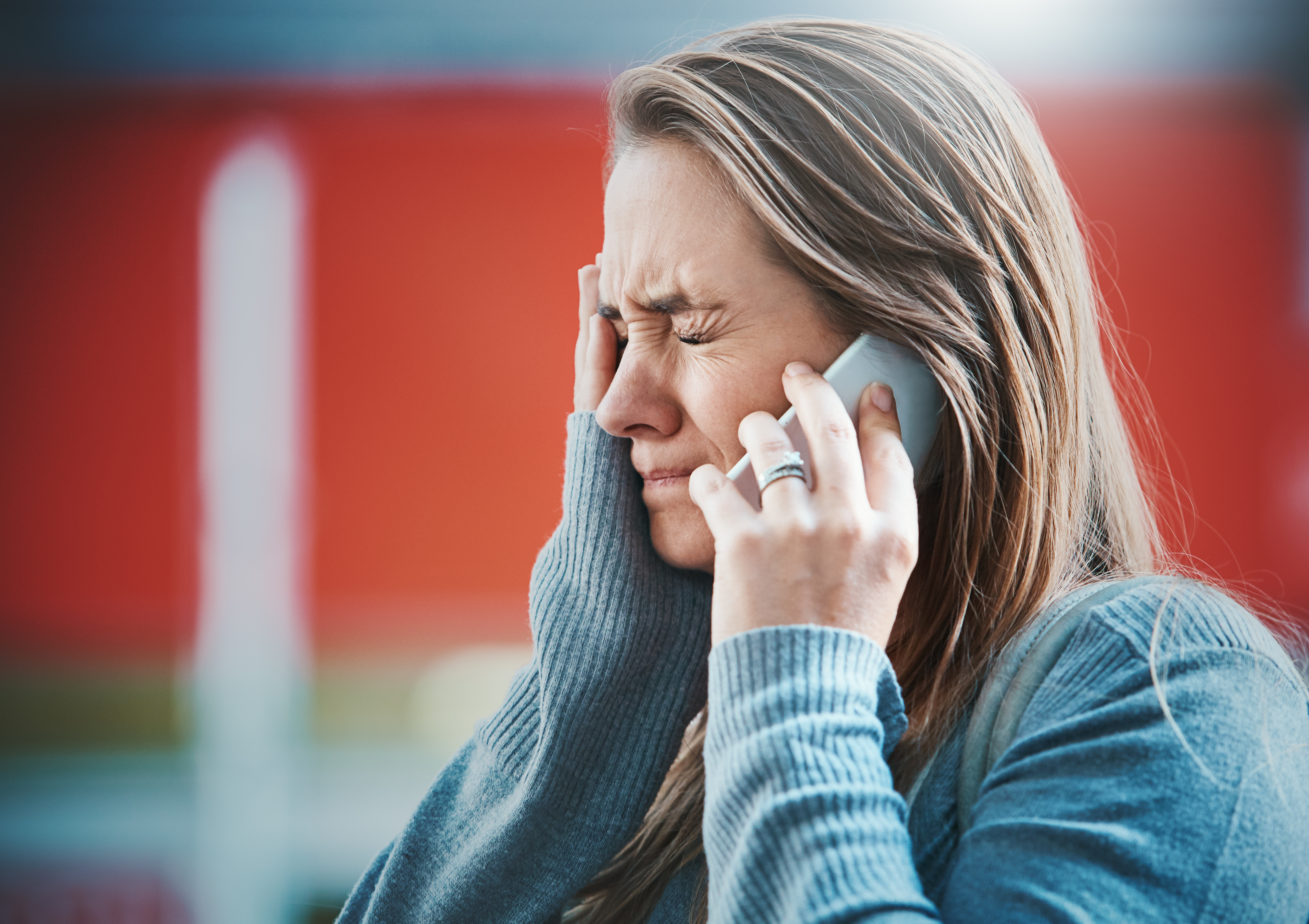 Young woman holding back tears on phone | Source: Getty Images
