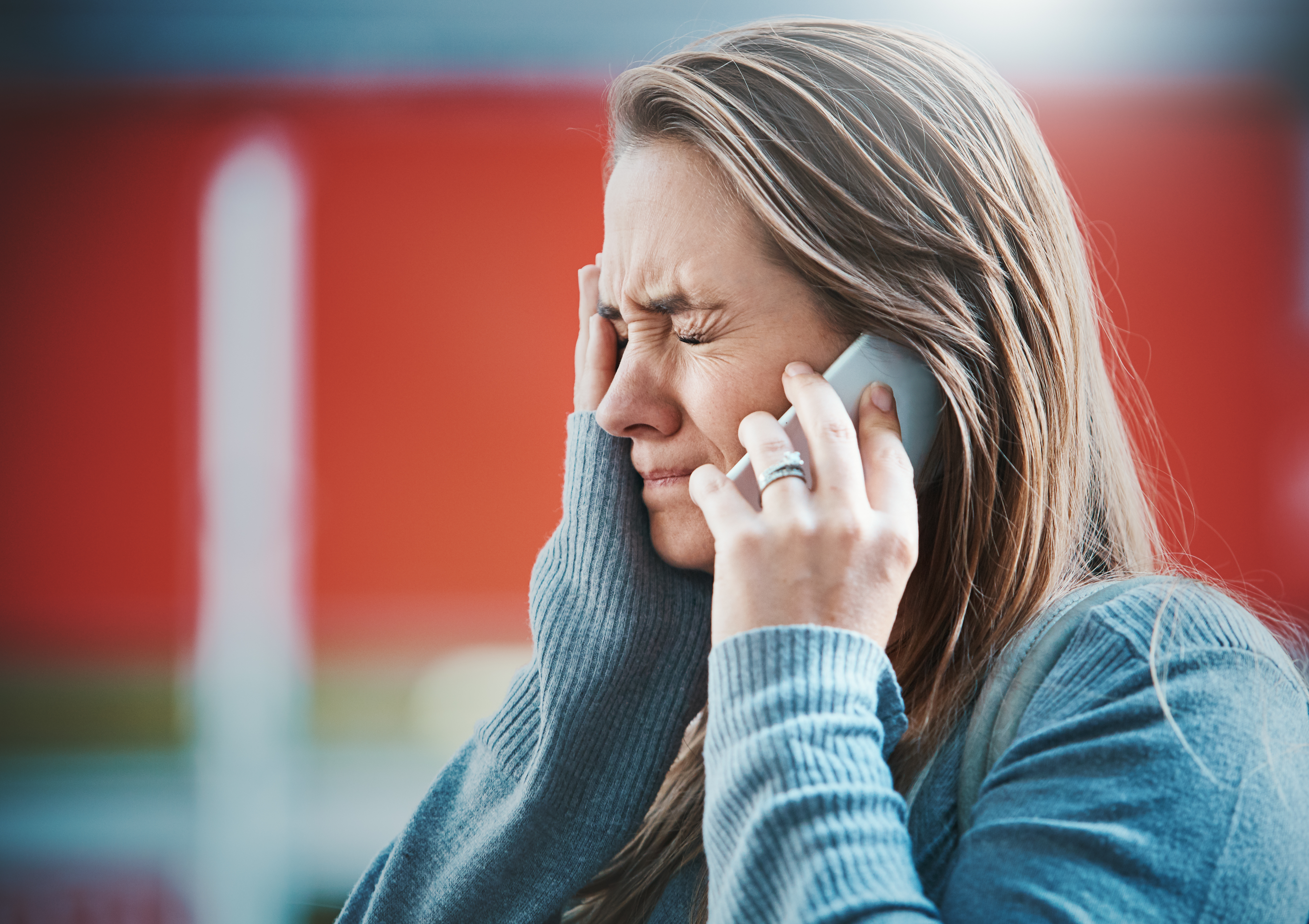 Une jeune femme retient ses larmes au téléphone | Source : Getty Images