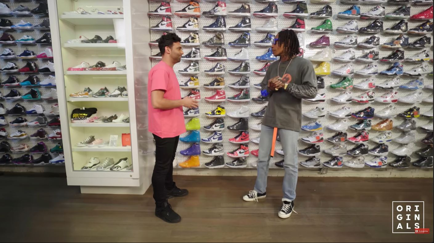 Standing in front of Stadium Goods' wall of coveted sneakers, Wiz Khalifa reflected on his evolution from skating in Jordans as a teenager to building his own signature style. | Source: YouTube/Complex