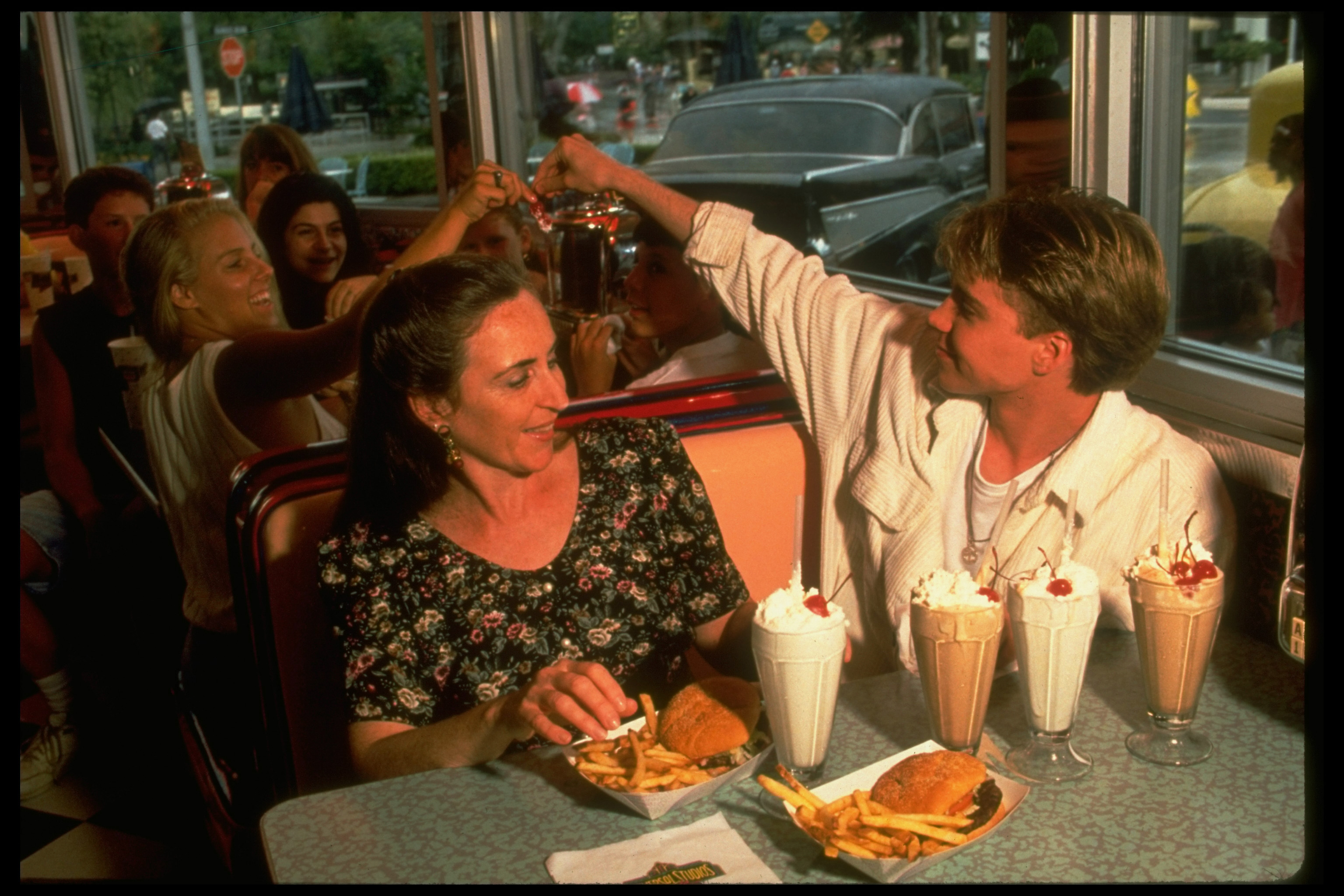 The teen idol handing a souvenir to a fan while dining with his mother in 1994 | Source: Getty Images