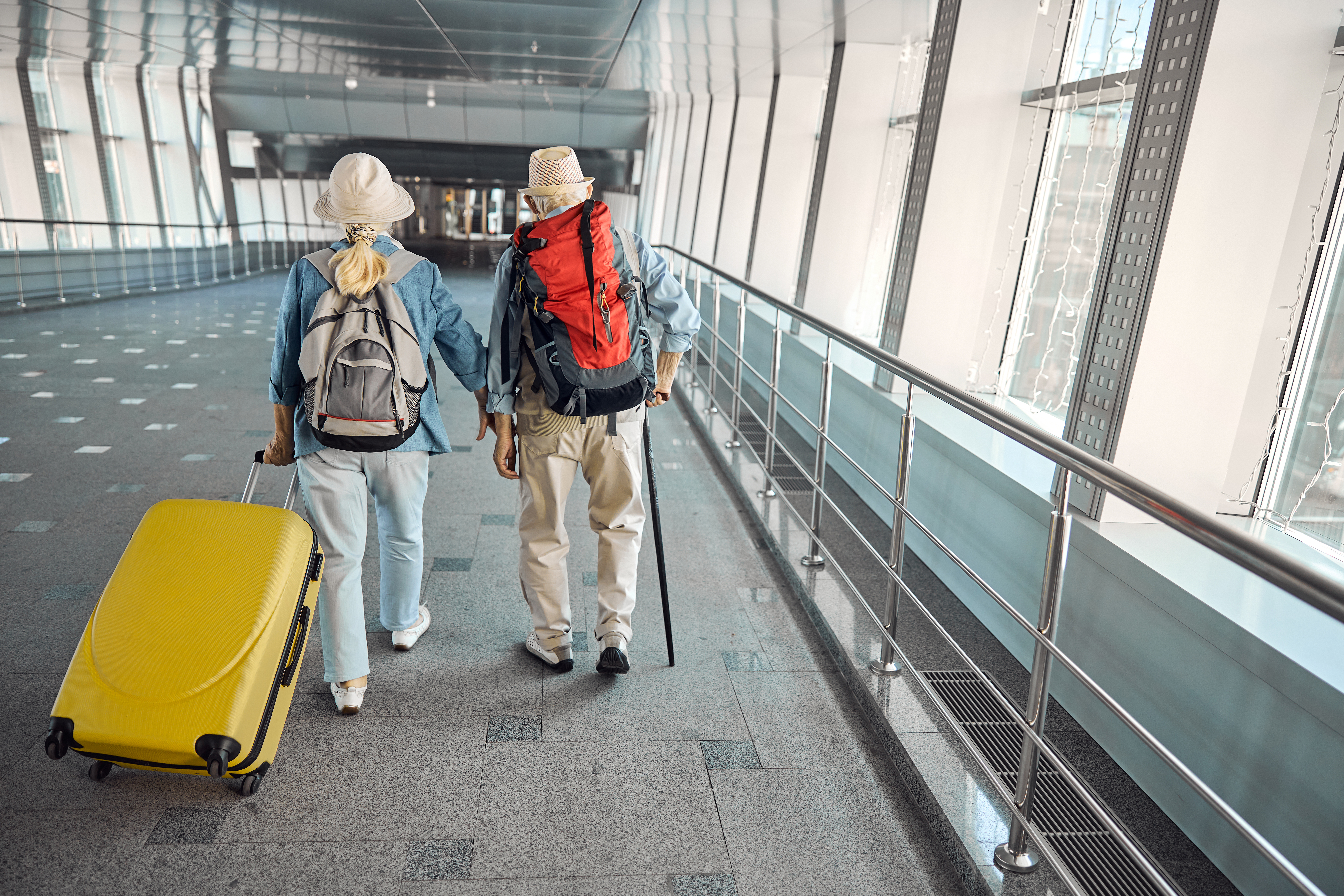 An elderly couple at the airport with their luggage | Souce: Getty Images