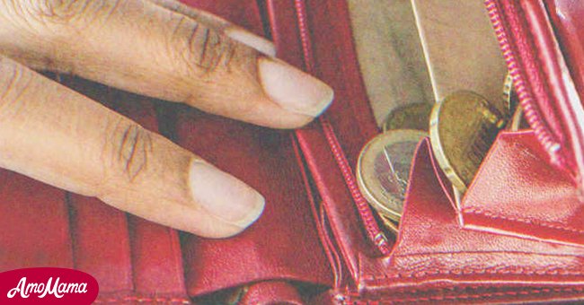 Hand reaching into a wallet | Source: Shutterstock