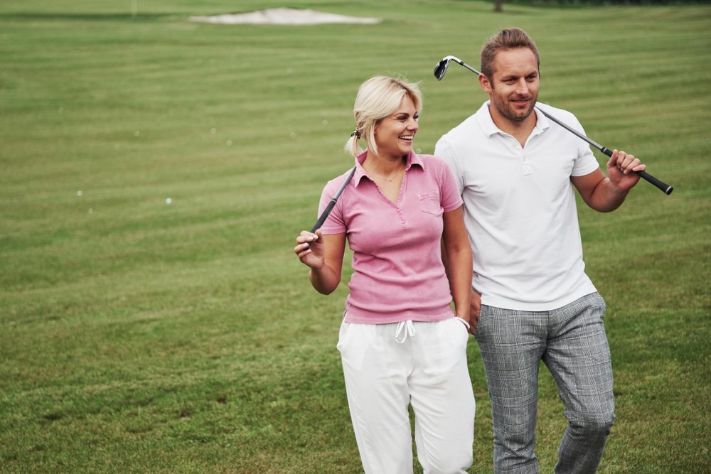 A couple playing golf on a golf course. | Photo: Shutterstock