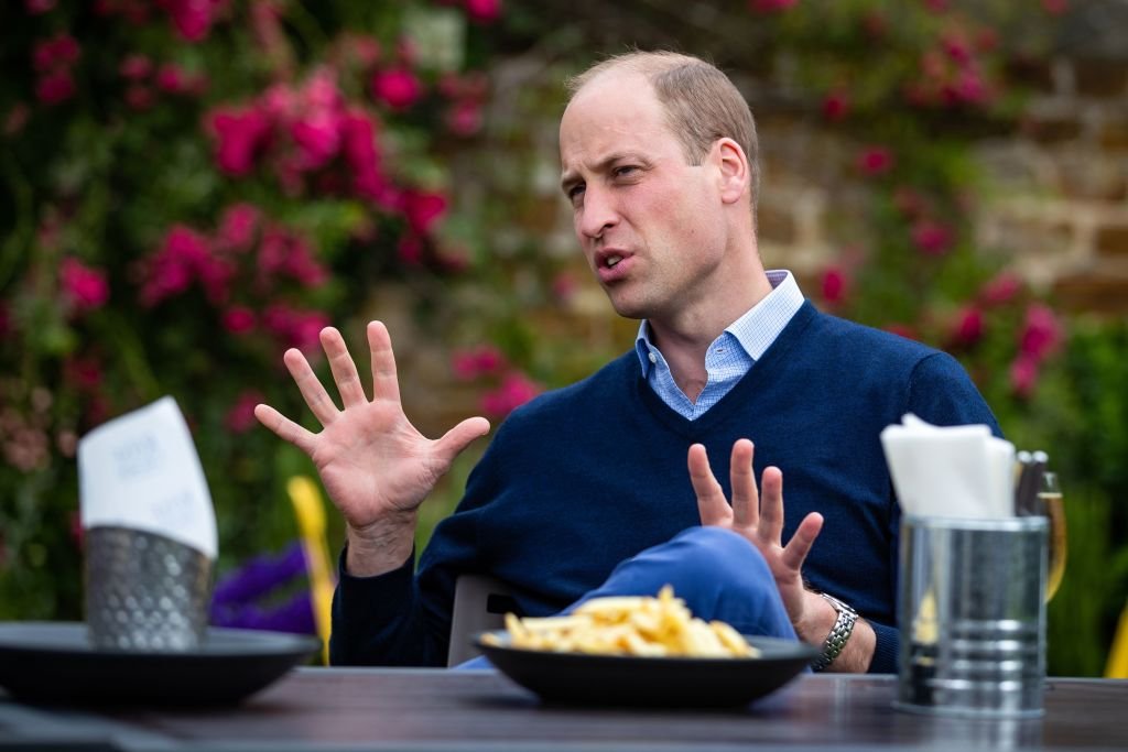 Britain's Prince William, Duke of Cambridge, gestures as he talks to the landlords and workers at The Rose and Crown pub in Snettisham in eastern England on July 3, 2020 | Source: Getty Images