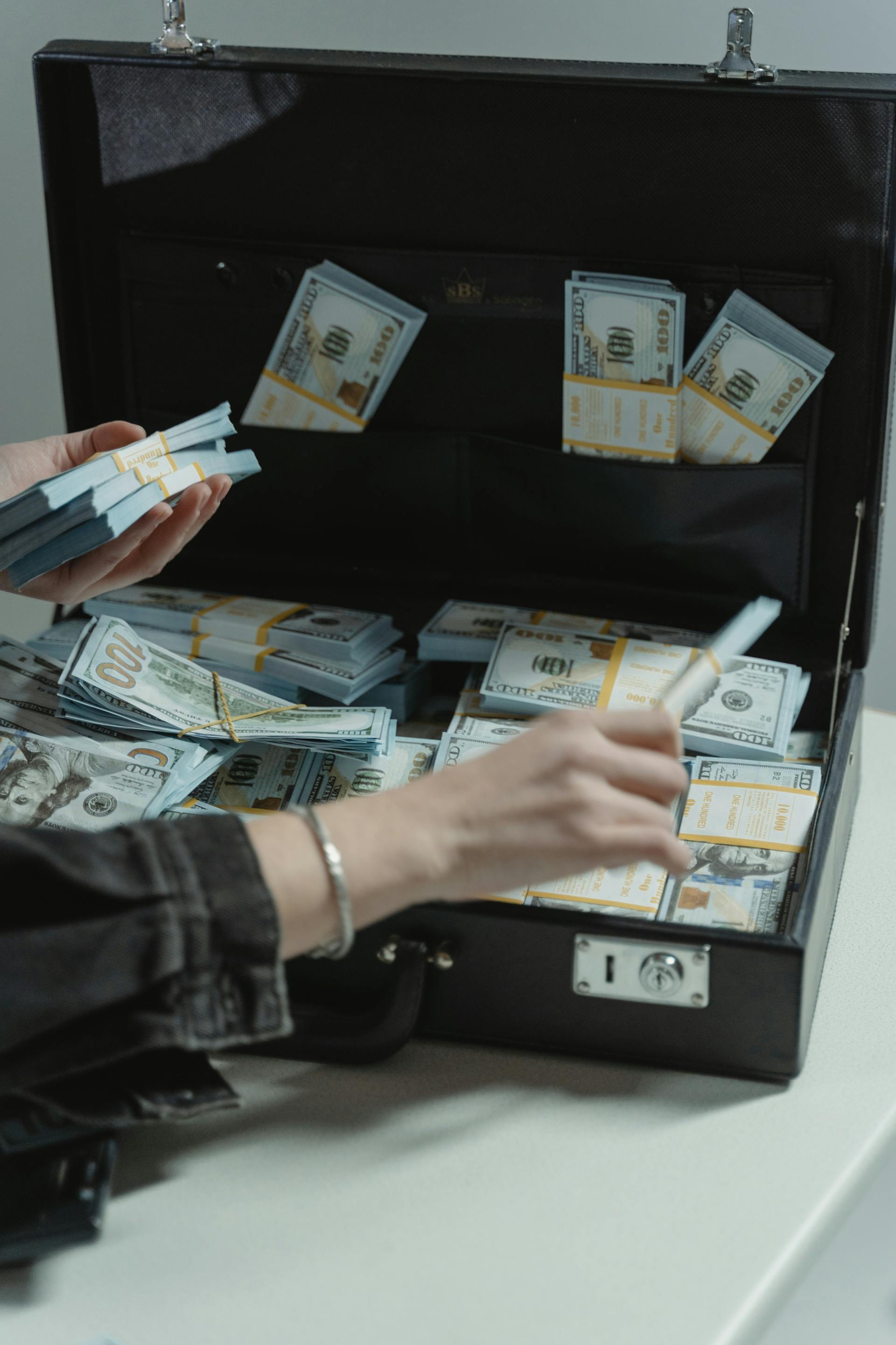 A person getting money from a briefcase | Source: Pexels