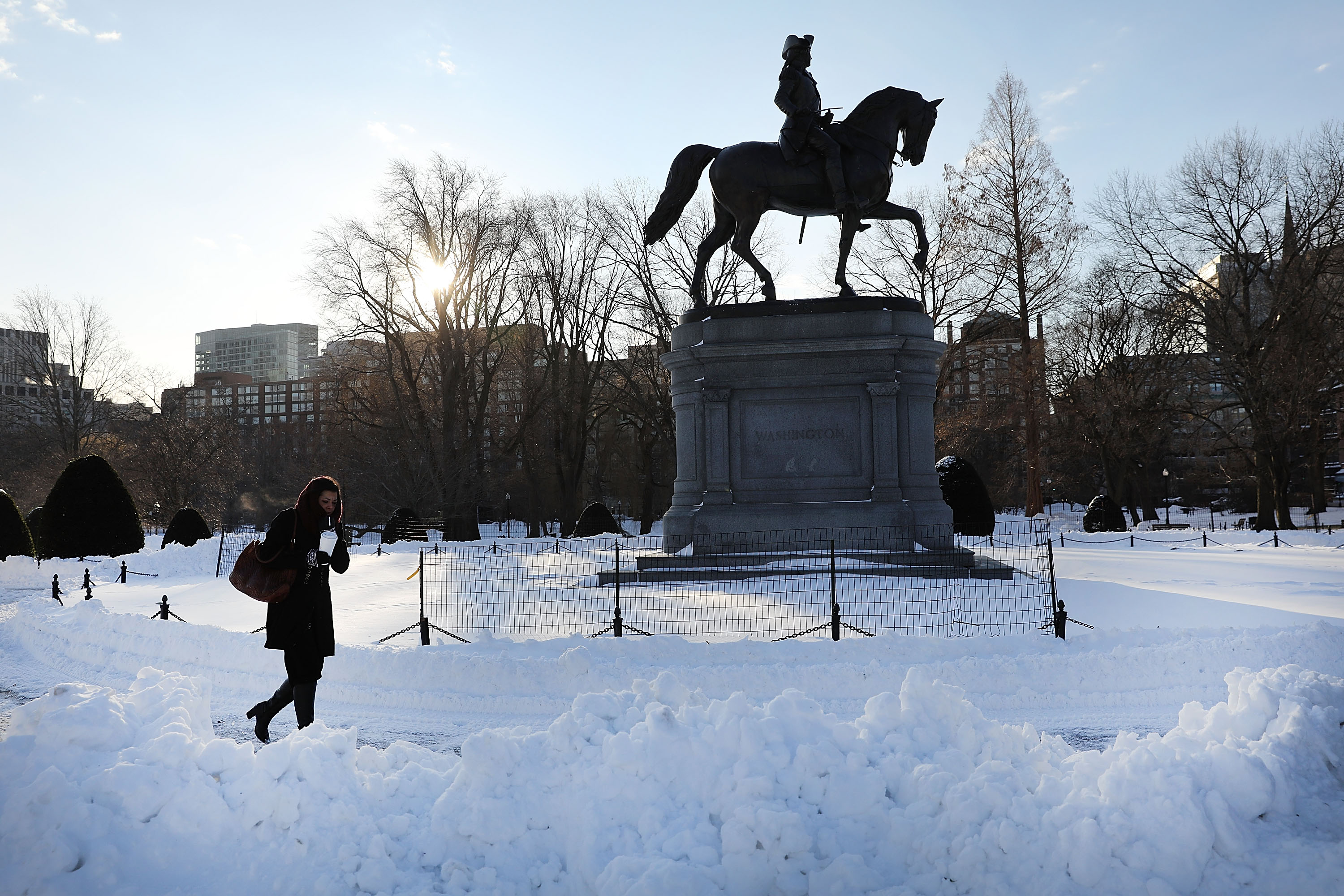 A woman walks by the Washington statue in the Public Garden the morning after a massive winter storm in Boston, Massachusetts, on January 5, 2018 | Source: Getty Images