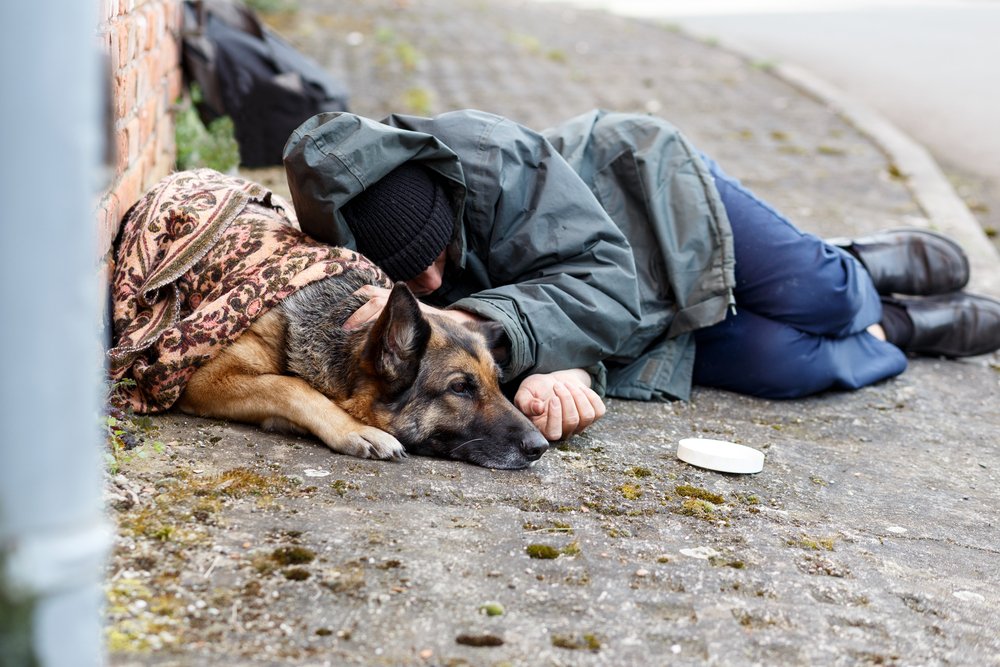 Hombre sin hogar durmiendo en el suelo junto a su perro. | Foto: Shutterstock