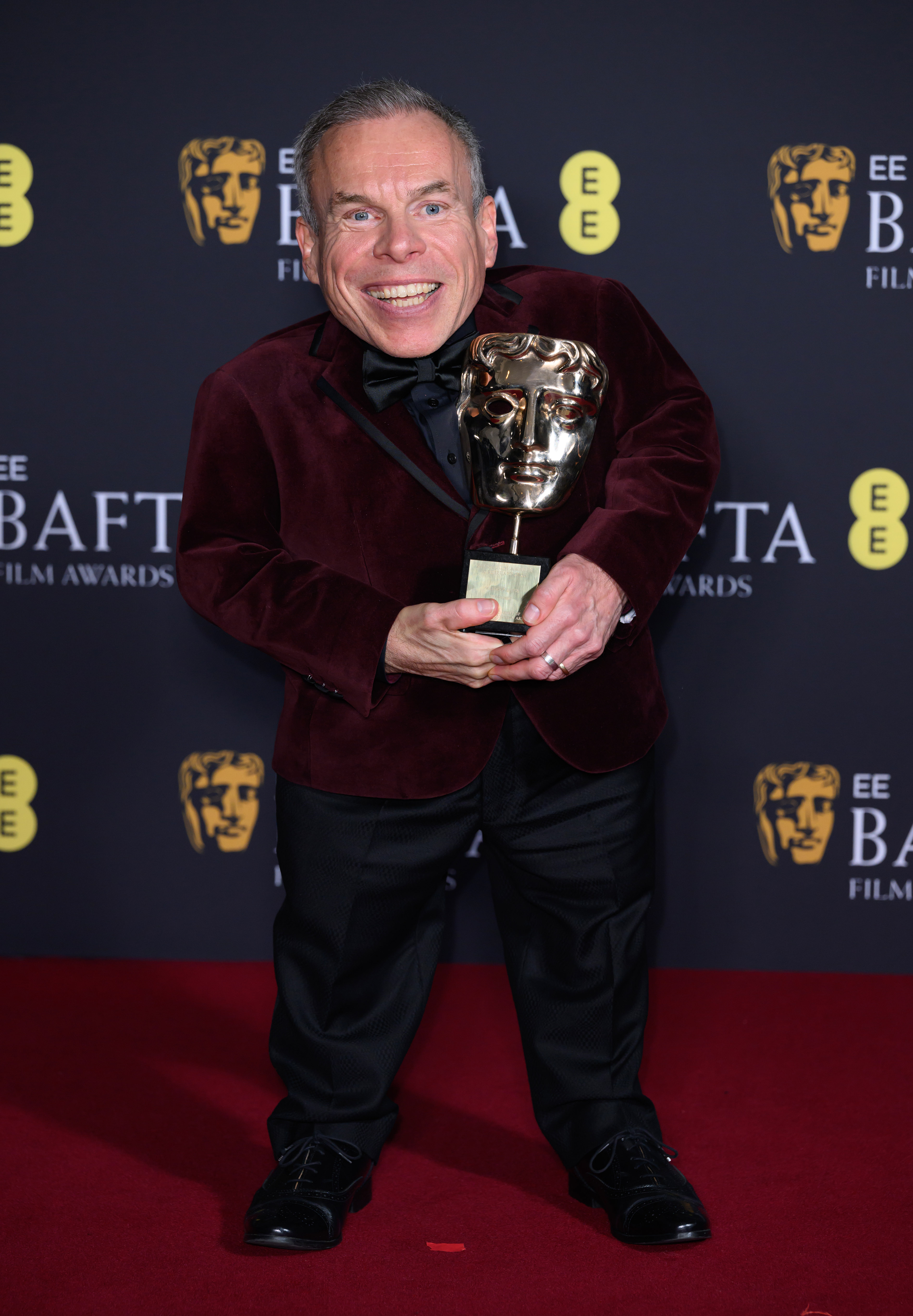 Warwick Davis poses with the Fellowship Award in the winners room during the 2025 EE BAFTA Film Awards at The Royal Festival Hall on 16 February in London, England. | Source: Getty Images