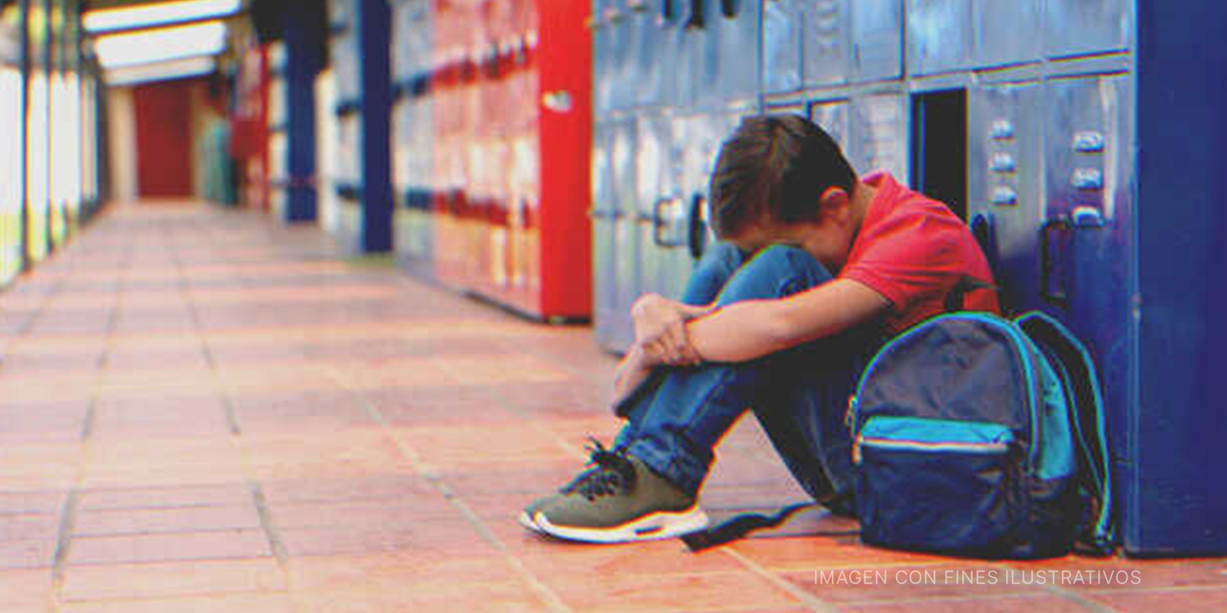 Niño sentado en el suelo llorando con su rostro entre sus rodillas. | Foto: Getty Images