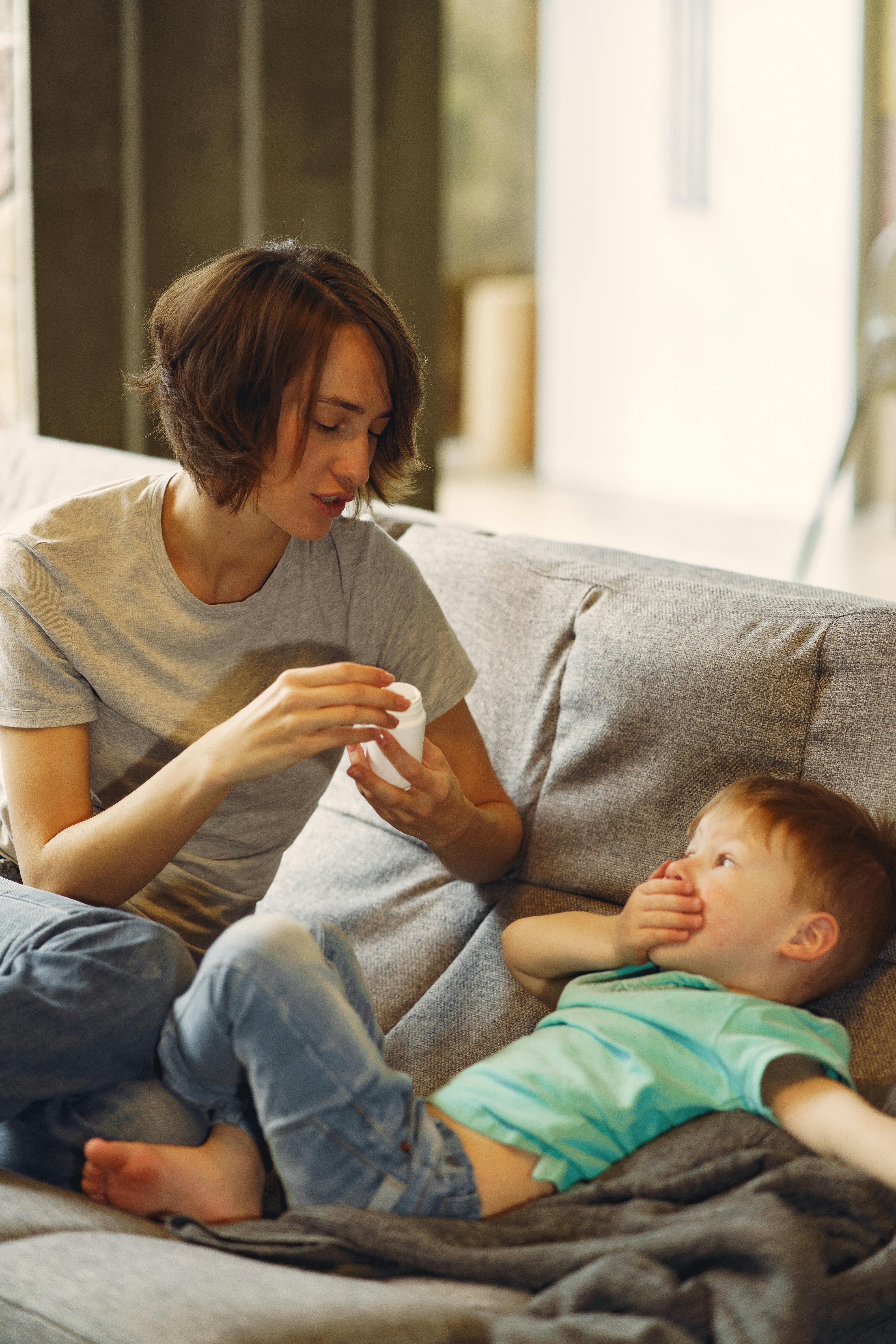 Boy with his mother on the couch, hand on his mouth | Source: Pexels