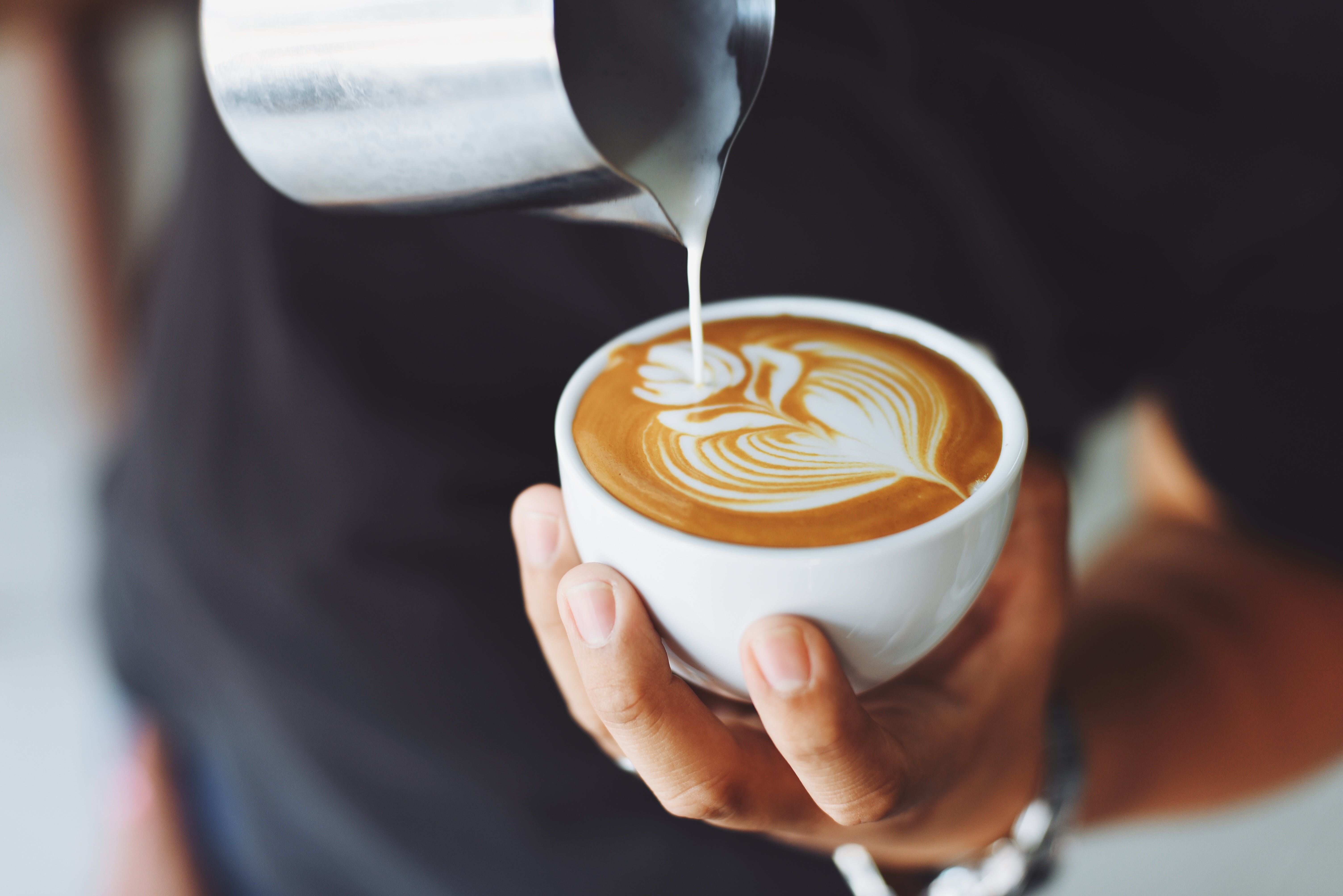 A person holding a cup of latte. | Source: Pexels