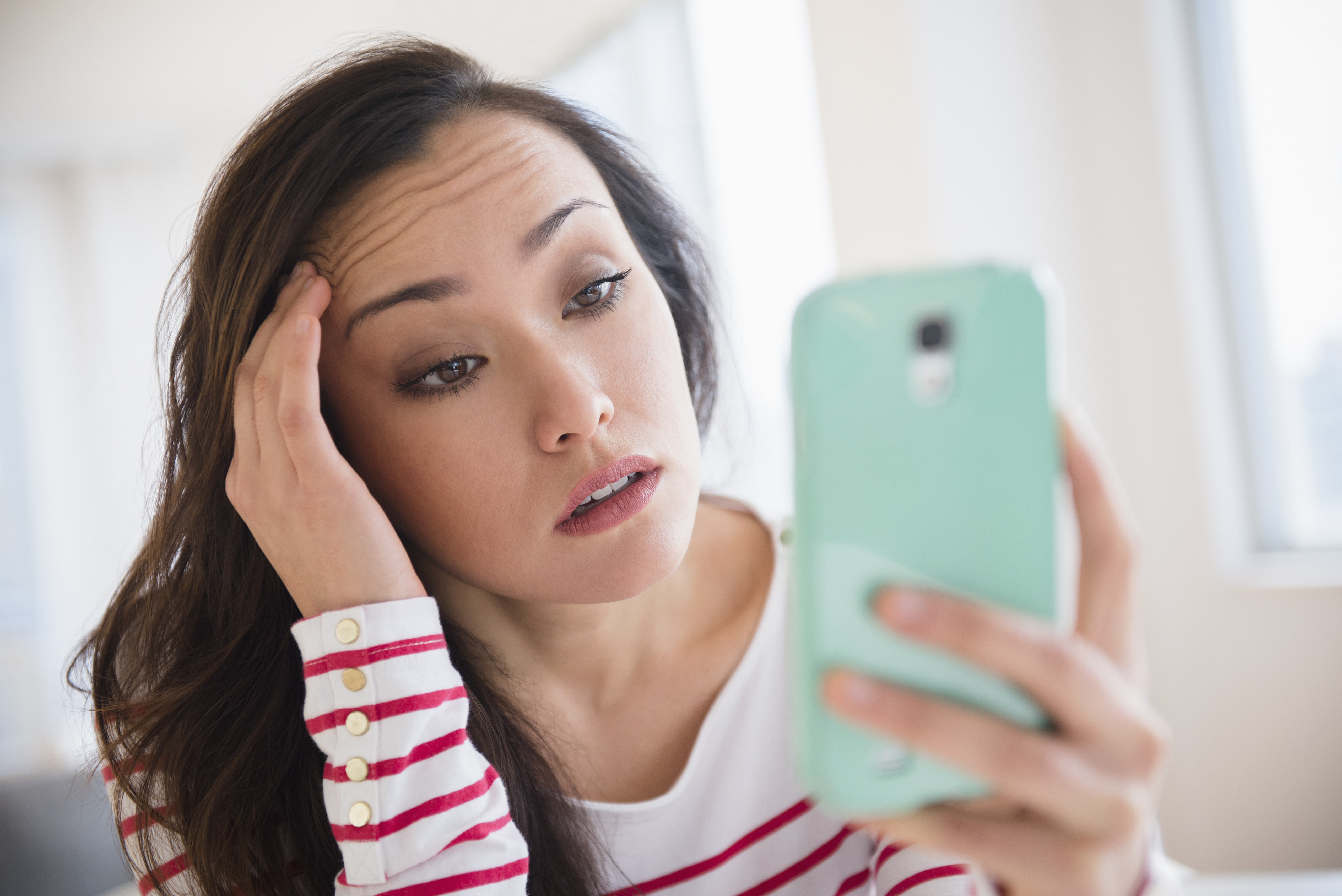 Stressed young woman looking at her phone | Source: Getty Images