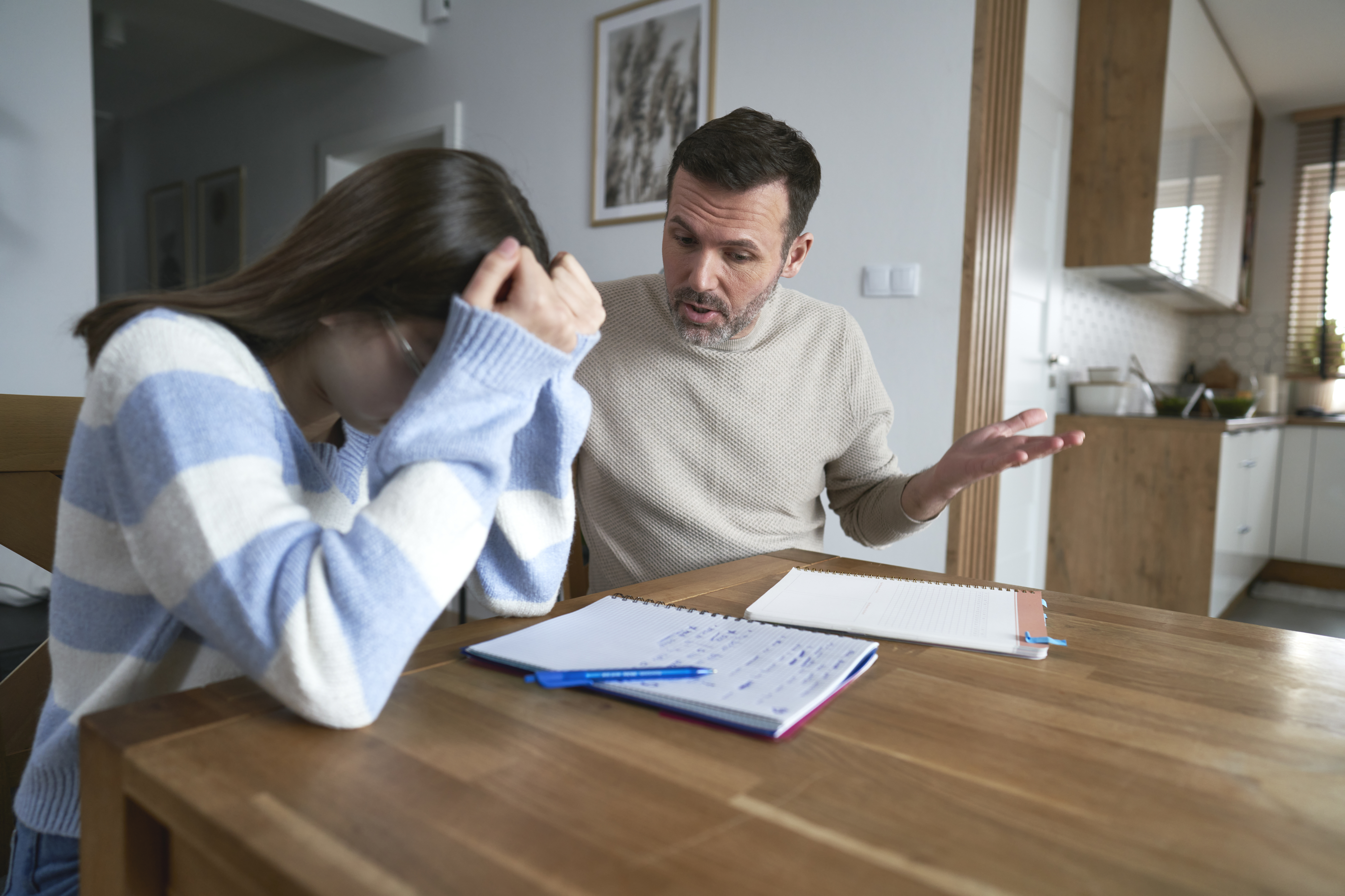 Angry father with teenager daughter make homework at home | Source: Getty Images