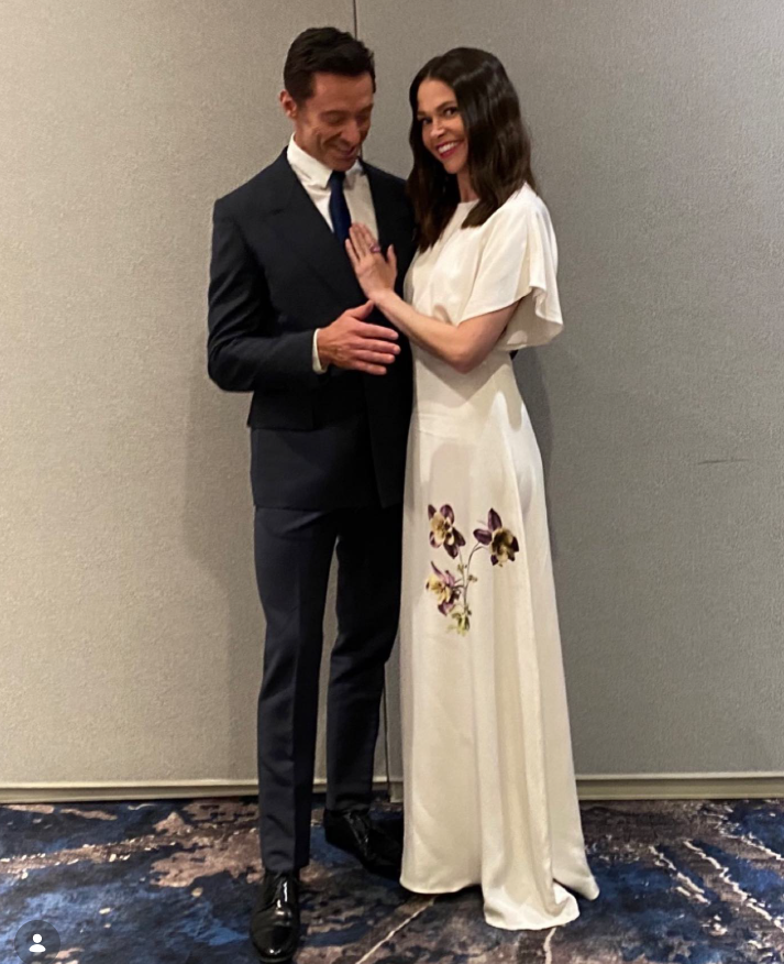 Hugh Jackman stands beside a smiling Sutton Foster in an elegant white gown with delicate floral detailing near the hem. | Source: Instagram/thehughjackman