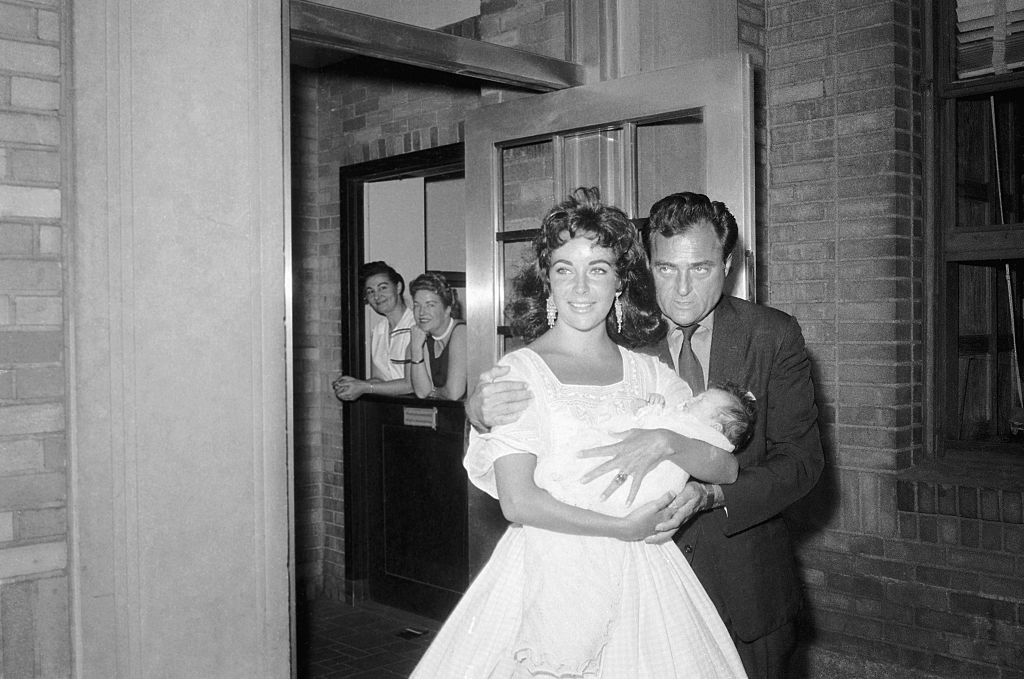 Elizabeth Taylor, Mike Todd, and their month-old daughter, Liza, as they leave Harkness Pavillion on September 3, 1957 | Photo: Getty Images