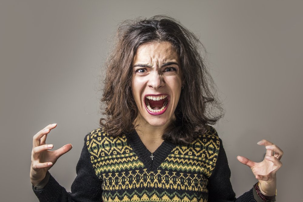 A frustrated woman screaming with rage. | Photo: Shutterstock