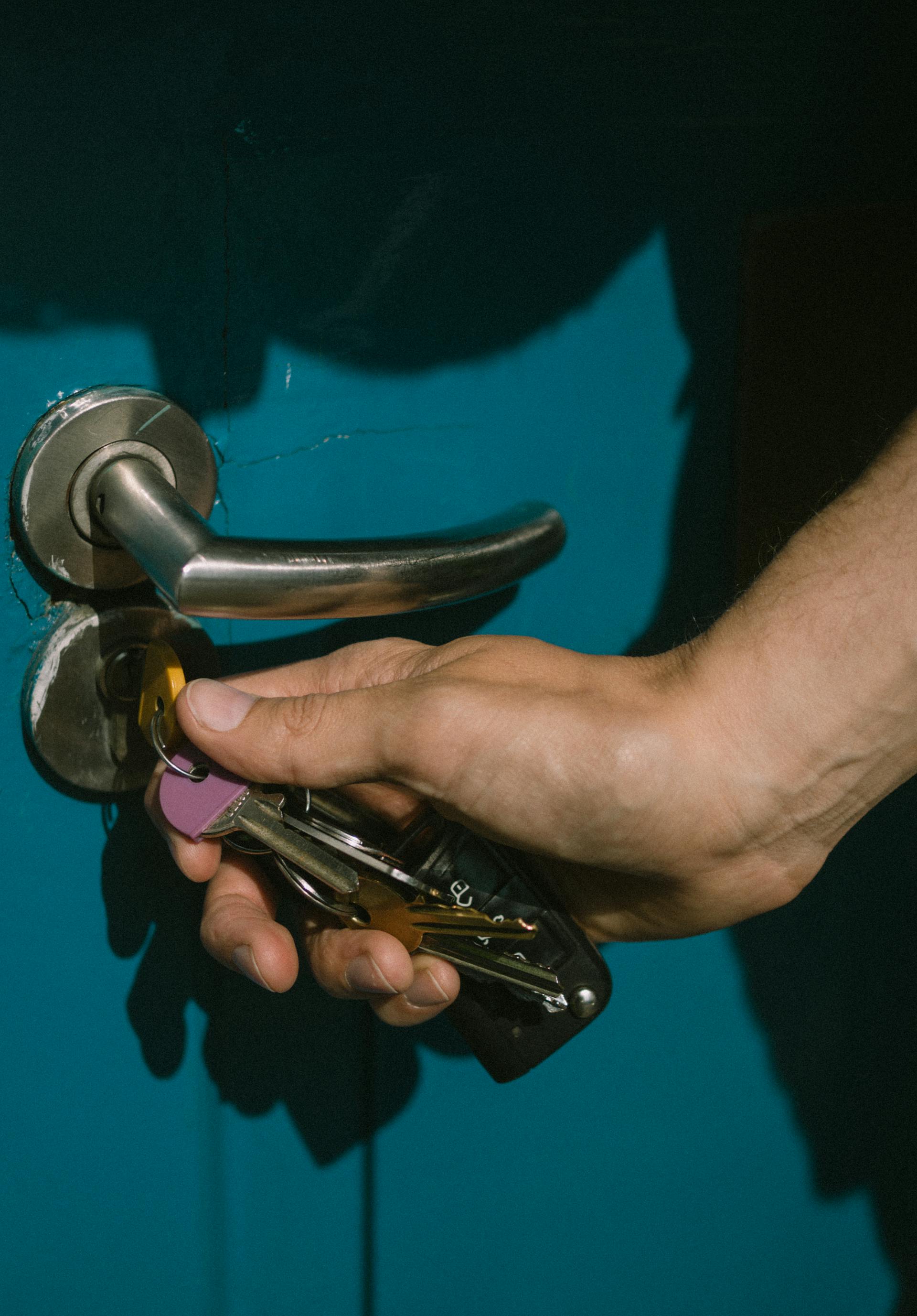 Close-up of a young man unlocking the door | Source: Pexels