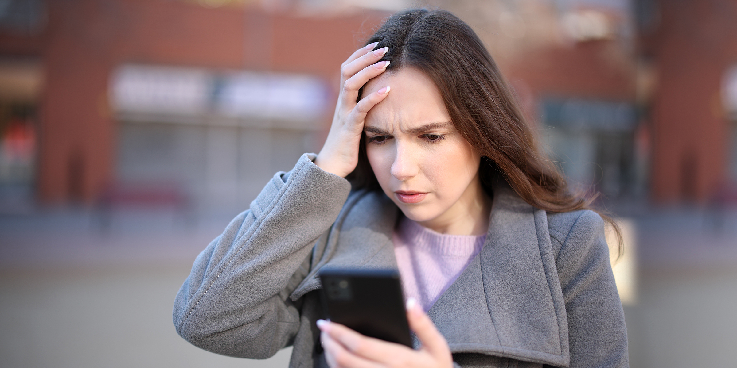 A shocked woman looking at her phone | Source: Shutterstock