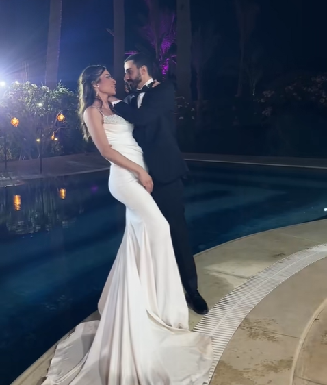 The bride and groom staring into each other's eyes as the groom supports her head with his hands before the viral moment, from a July 2025 video post | Source: TikTok/emadjoe1