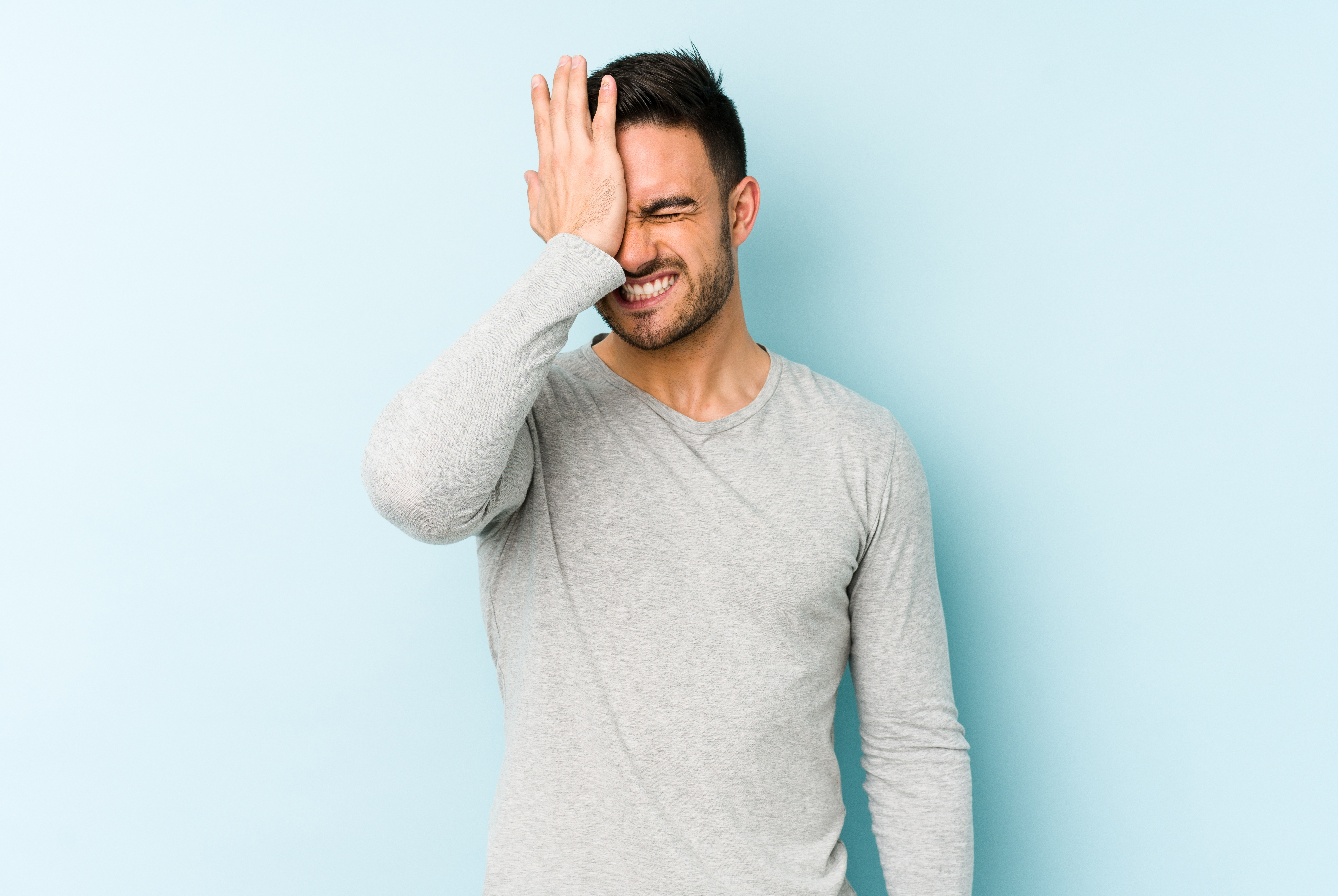 A man slapping his hand on his head in an act of forgetfulness | Source: Shutterstock