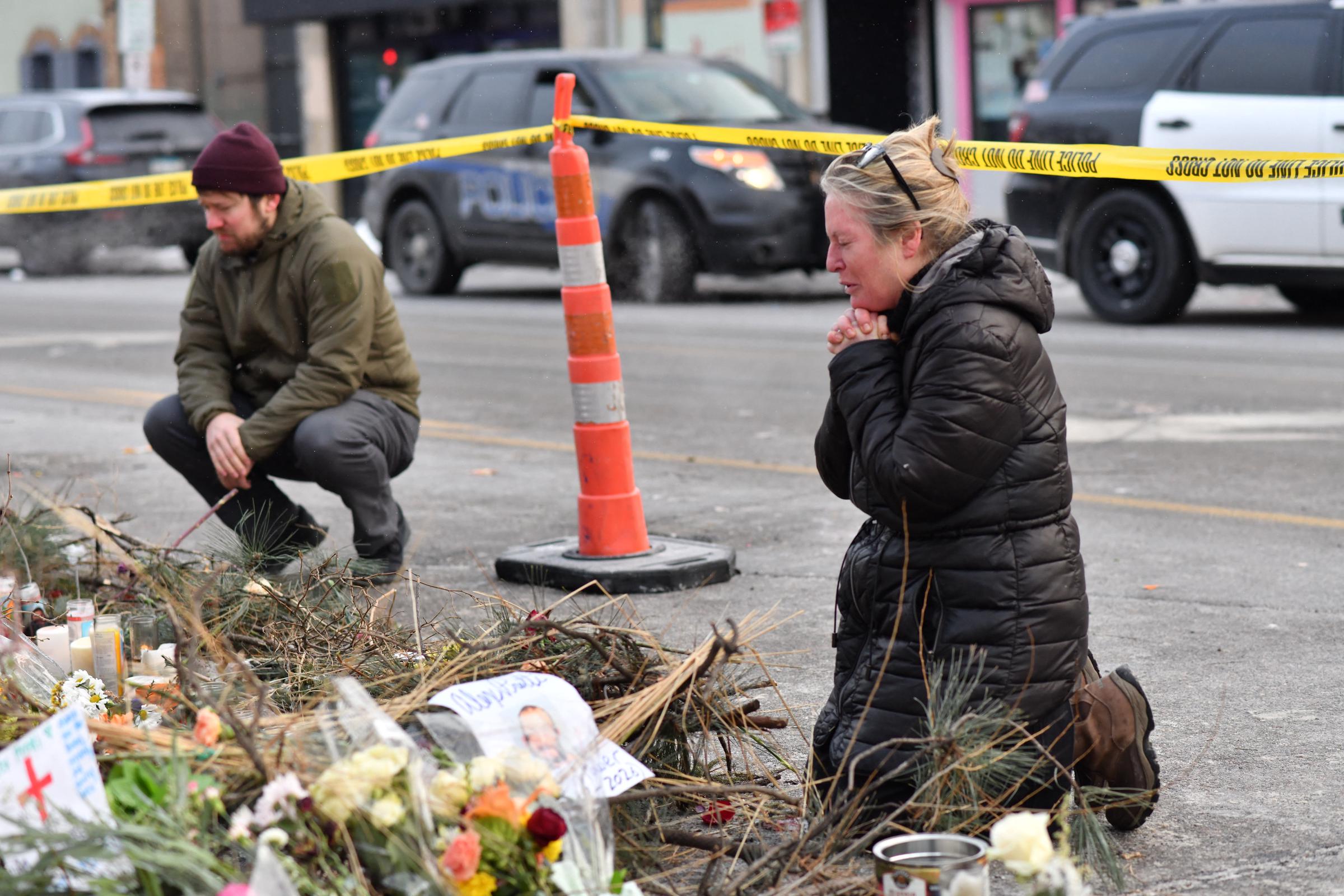 Mourners kneel at a makeshift memorial in the area where Alex Pretti was shot by federal immigration agents on January 25, 2026, in Minneapolis, Minnesota | Source: Getty Images
