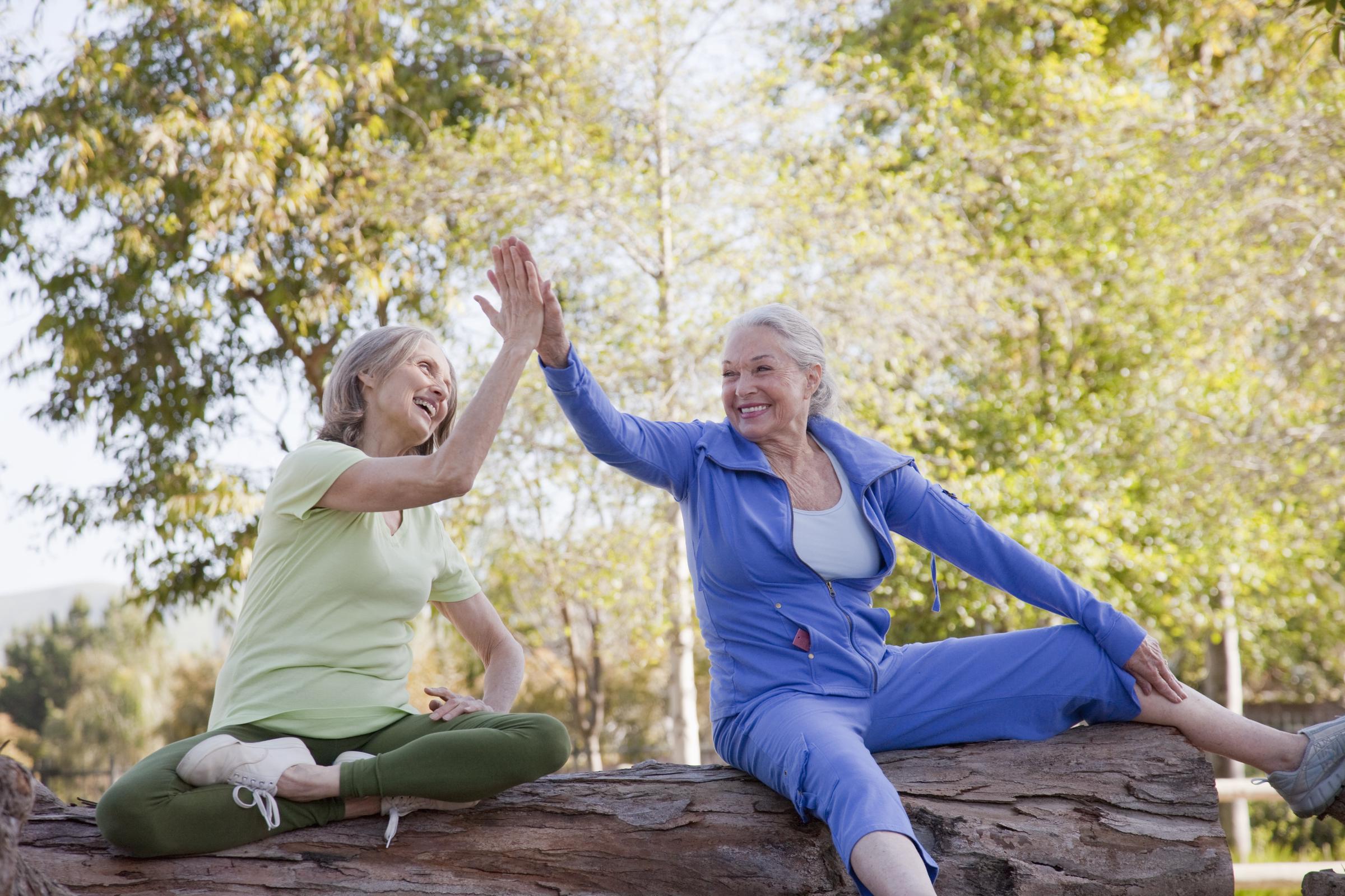 Two women high-fiving outdoors | Source: Getty Images