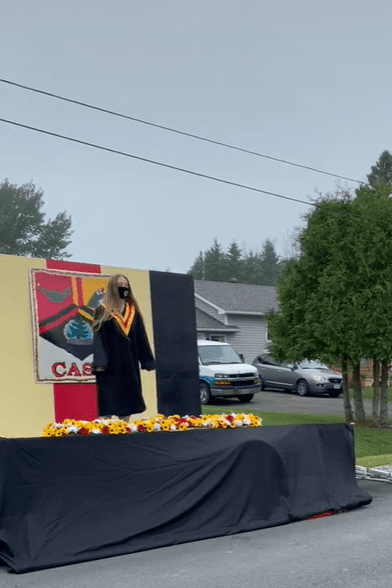 Canadian student standing on the Central Algoma Secondary School's (CASS) portable graduation stage while holding their high school diploma. │ Source: TikTok/leashorlando