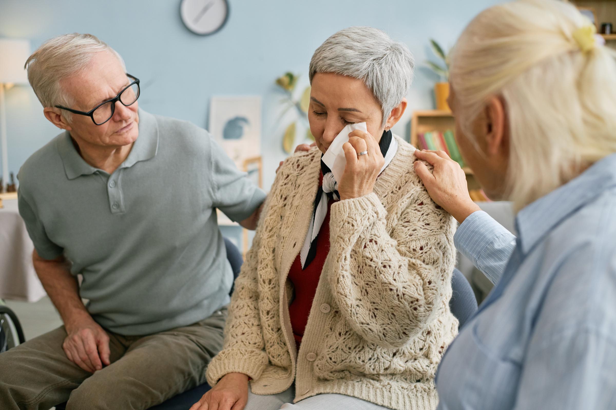 A couple consoling a grieving woman | Source: Shutterstock