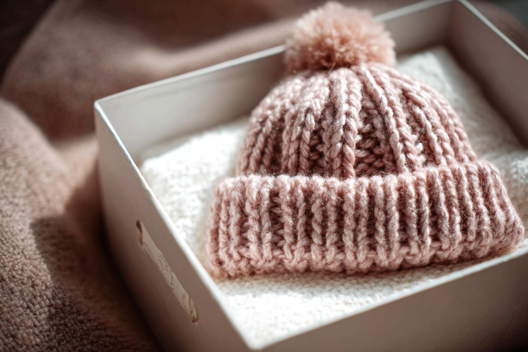 A hand-knit cap for a baby girl | Source: Midjourney