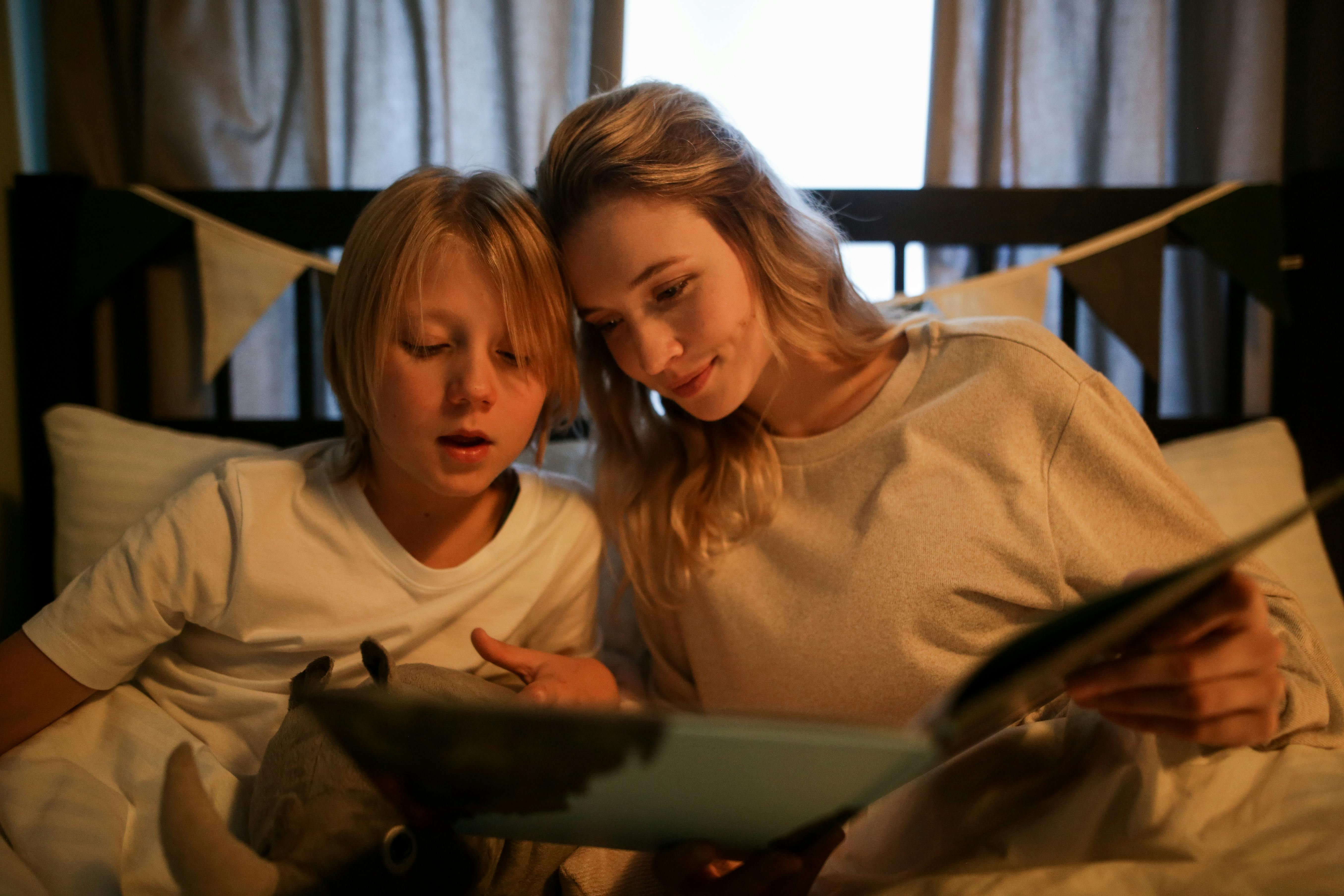 A mother and son reading a book | Source: Pexels