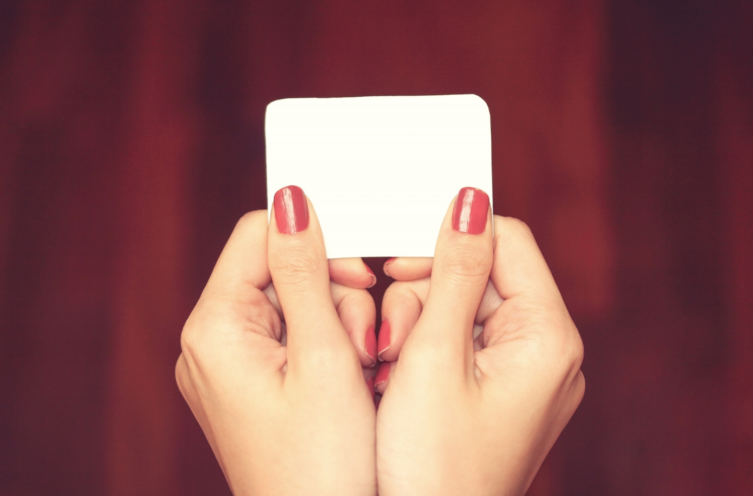 Close-up shot of a woman holding a piece of plain white paper | Source: Freepik