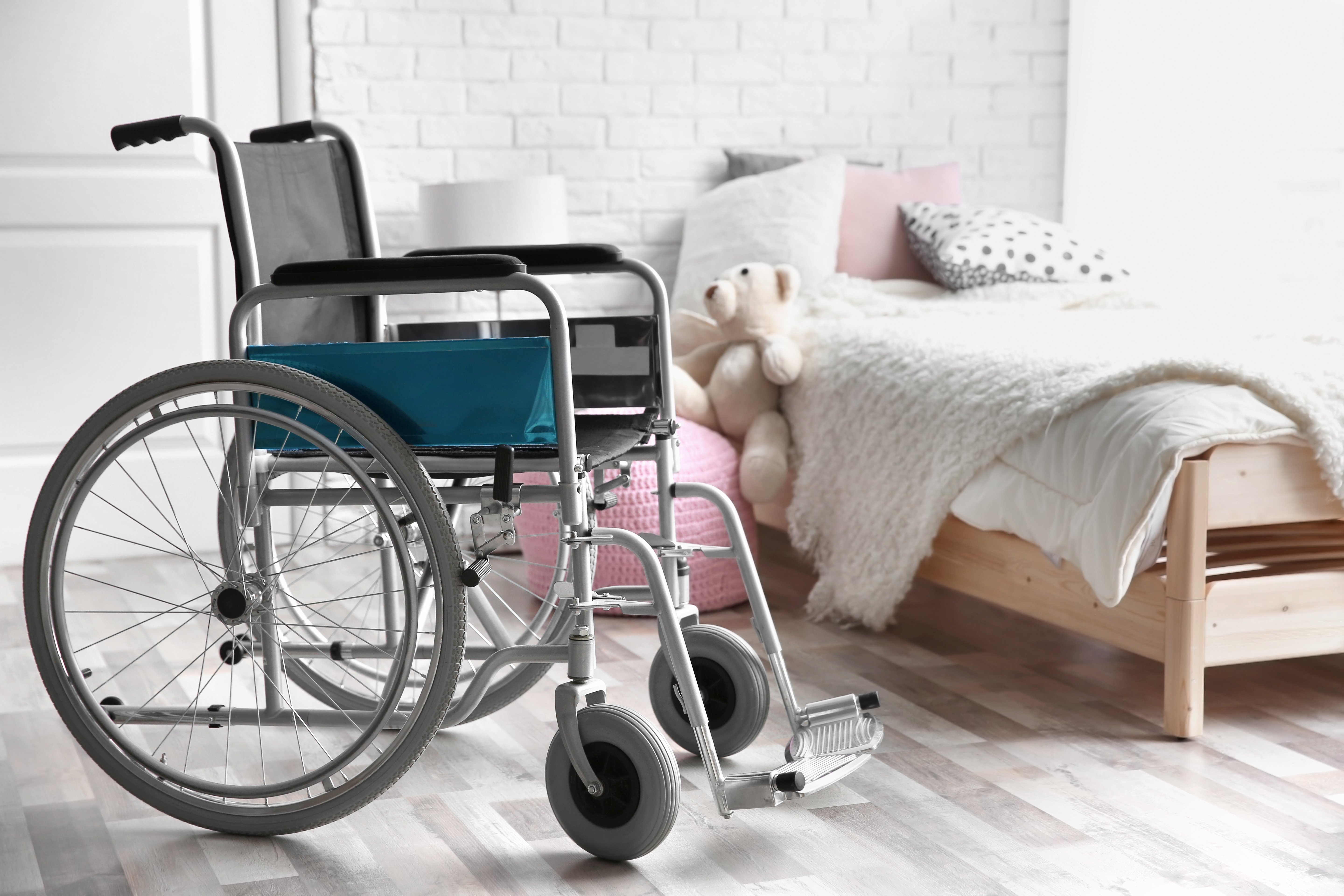 Picture of empty wheelchair next to a bed. | Source: Shutterstock