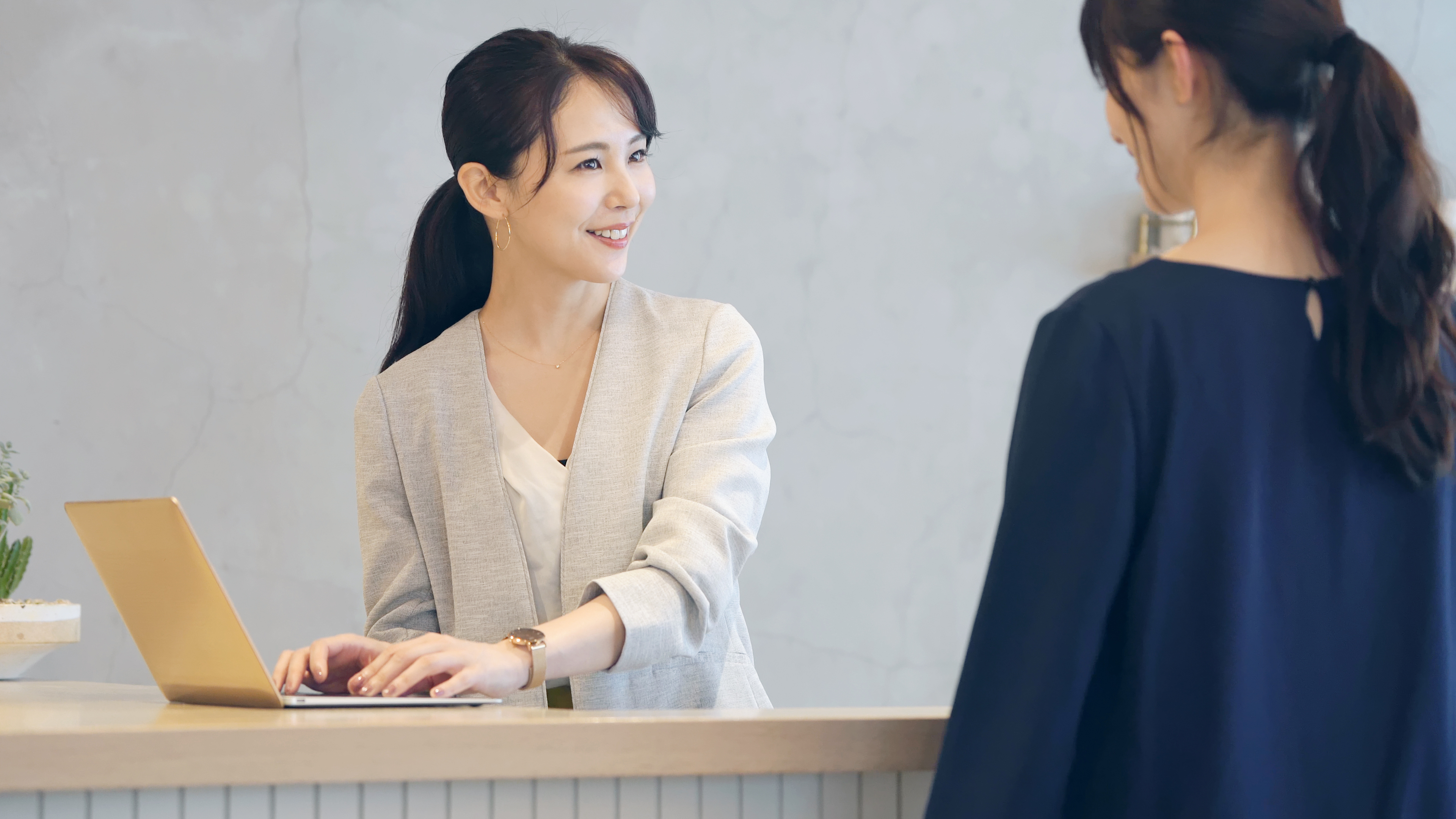 A woman talking to an Asian receptionist | Source: Shutterstock