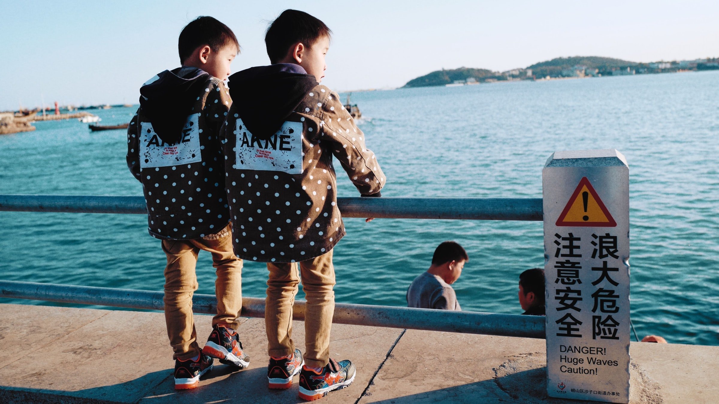 Twin boys standing by the lake. | Source: Unsplash