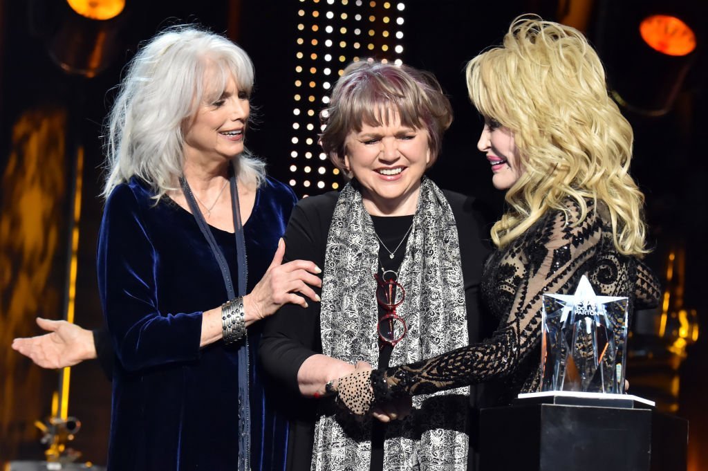 Emmylou Harris and Linda Ronstadt present Dolly Parton with an award at MusiCares Person of the Year in Los Angeles, California on February 8, 2019 | Photo: Getty Images