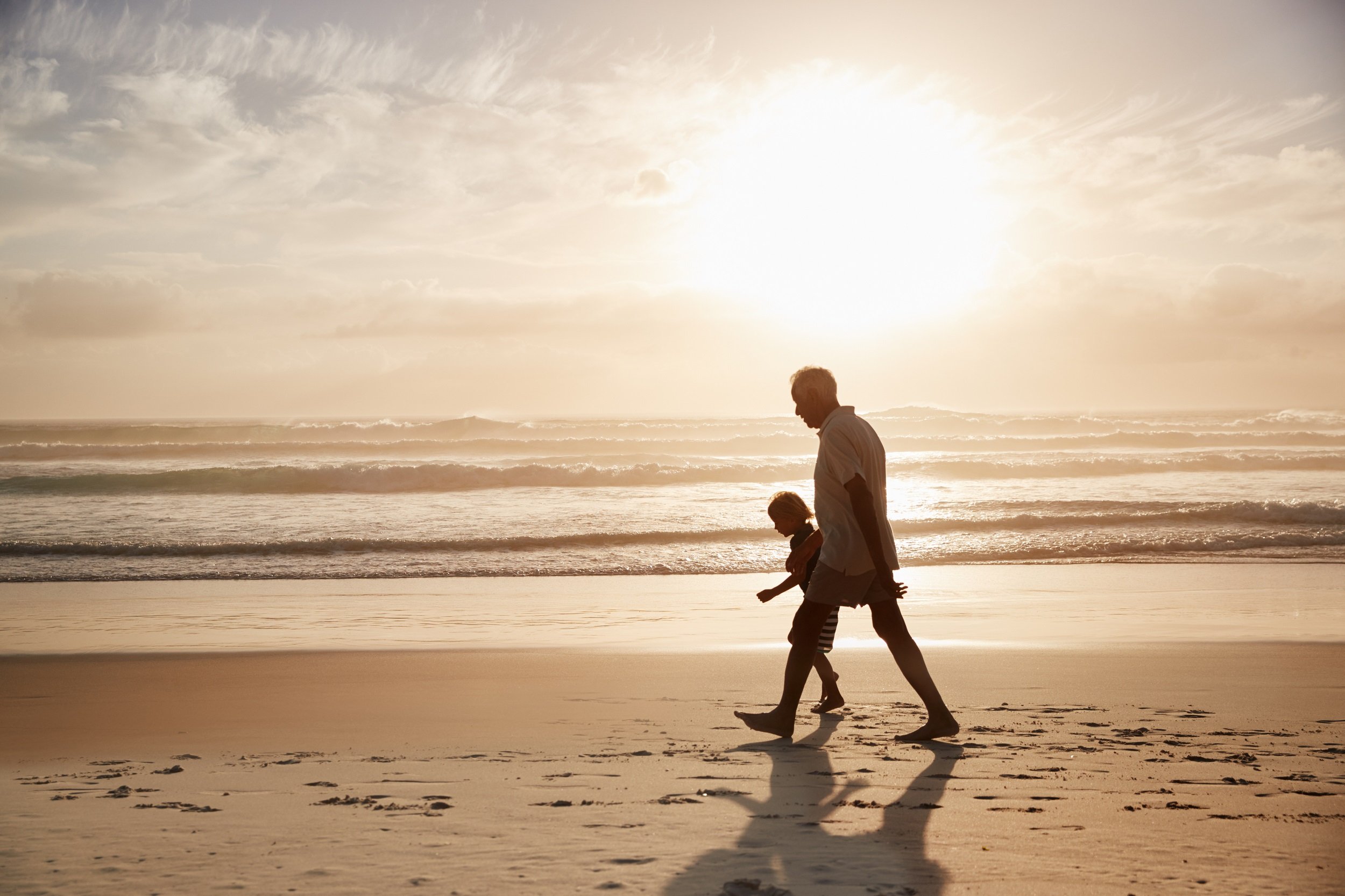 Abuelo camina por la playa con su nieta. | Foto: Shutterstock
