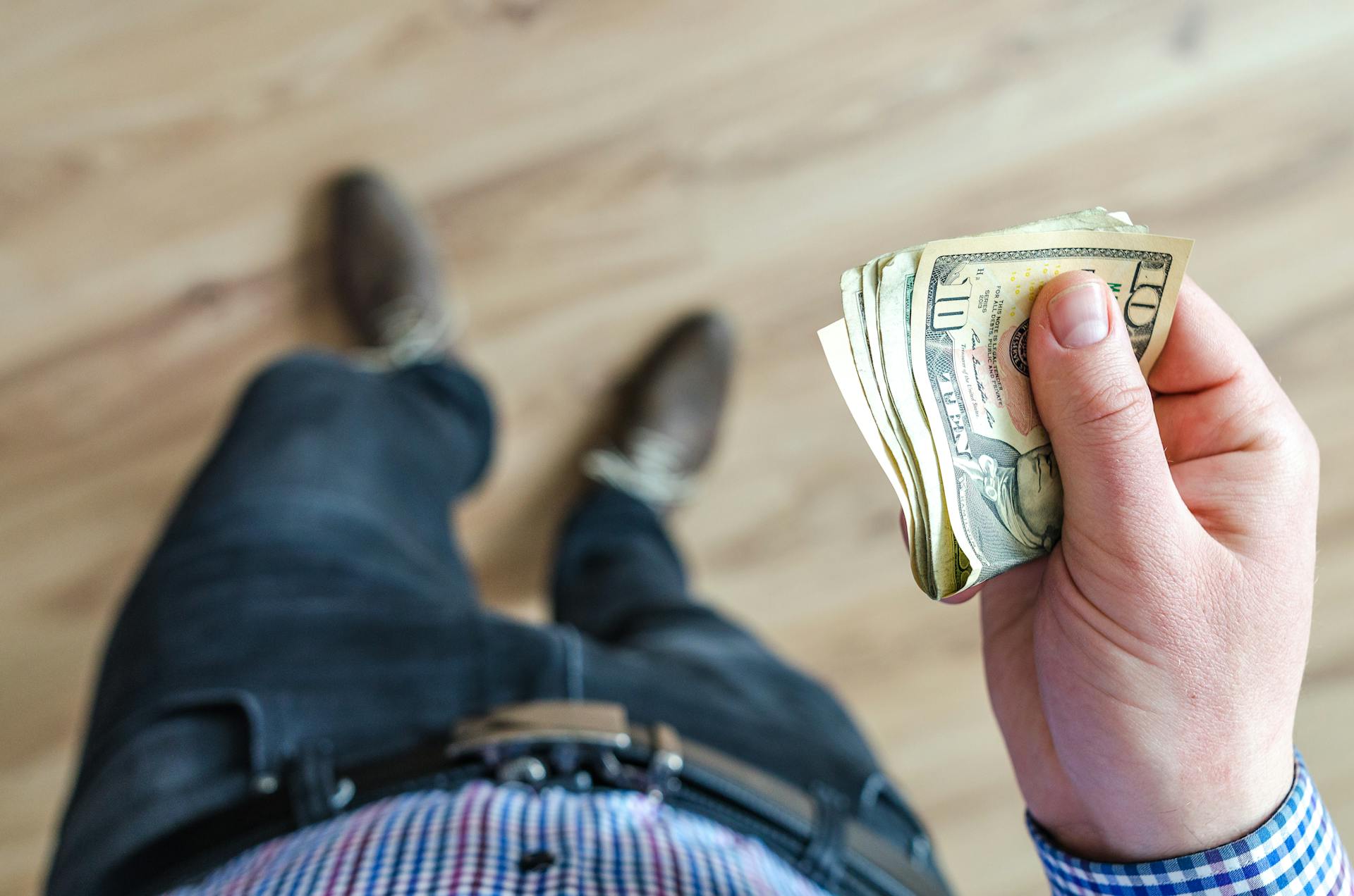 A person holding dollar bills | Source: Pexels