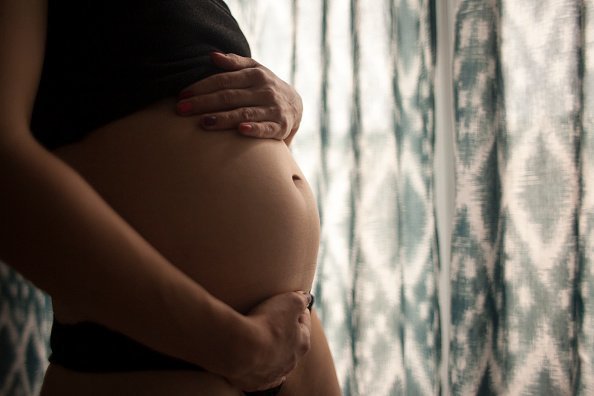 A pregnant woman holds her stomach | Image: Getty Images