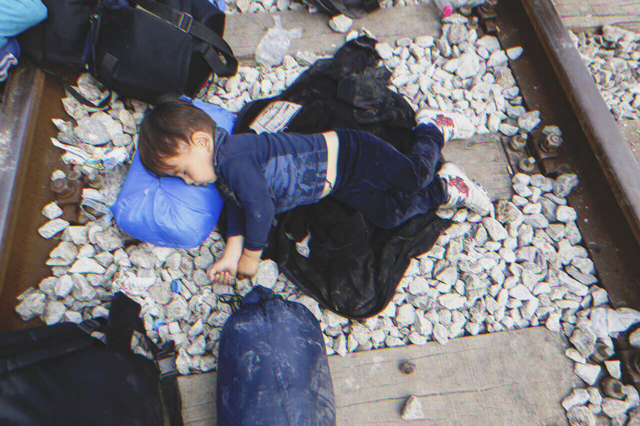 Young boy lying on train tracks | Source: Shutterstock
