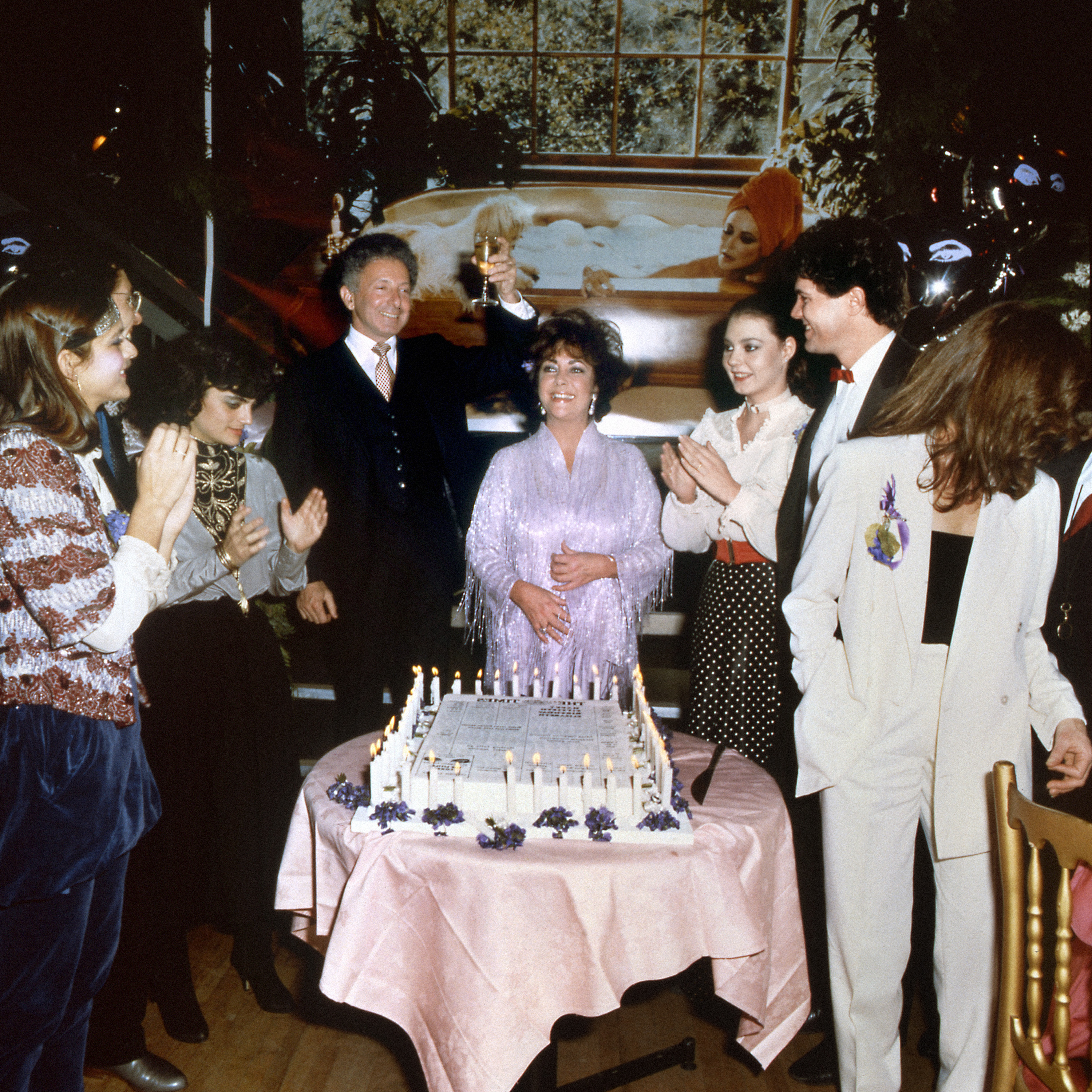 Theater producer Zev Bufman toasts to actress Elizabeth Taylor (C) during her 50th birthday party at Legends, Others are (2nd L) son-in-law Steven Carson, and his wife, Maria, daughter of Liz and Richard Burton, daughter Liza Todd, Hap Tivey and Aileen Getty-Wilding, | Source: Getty Images